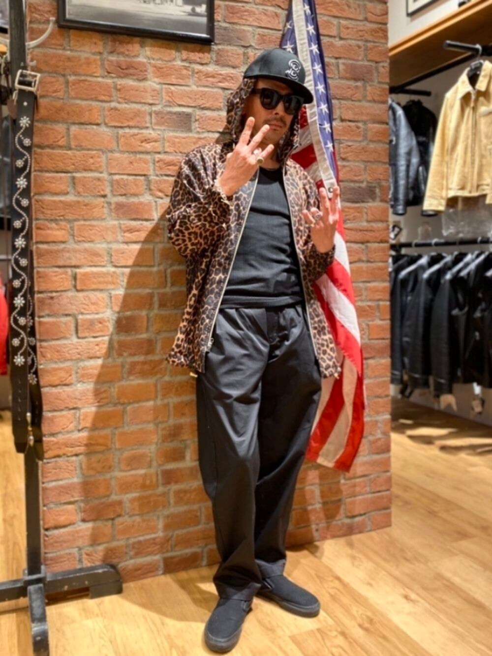 ブラック系のスラックス、ブラック系のタンクトップ、シルバー系のブレスレットを着用したメンズの夏コーディネートの1枚目の写真