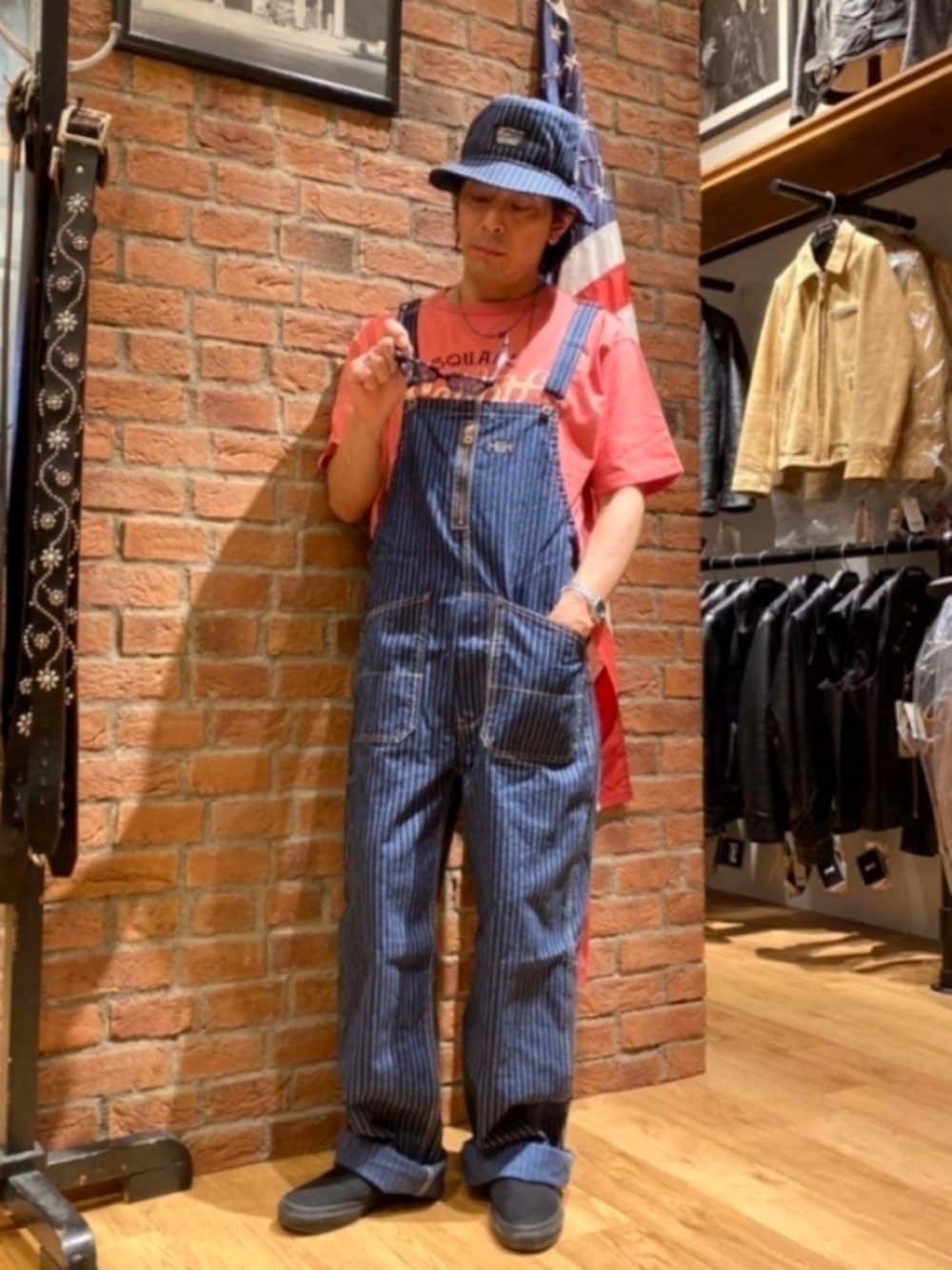 「ネオンカラー、プリントT、COOLなこのコが仲間入り、夏セールで買いました、バケットハット、ロゴT、メガネ男子、オーバーオール、ストライプ、ビッグシルエット」｜「VANSのVANS CLASSIC SLIP-ON (BLACK/BLACK)（スリッポン、ブラック系）」を使った、総料理長（schottのイケオジ）さん（メンズ・170cm）の夏コーディネートの1枚目の写真