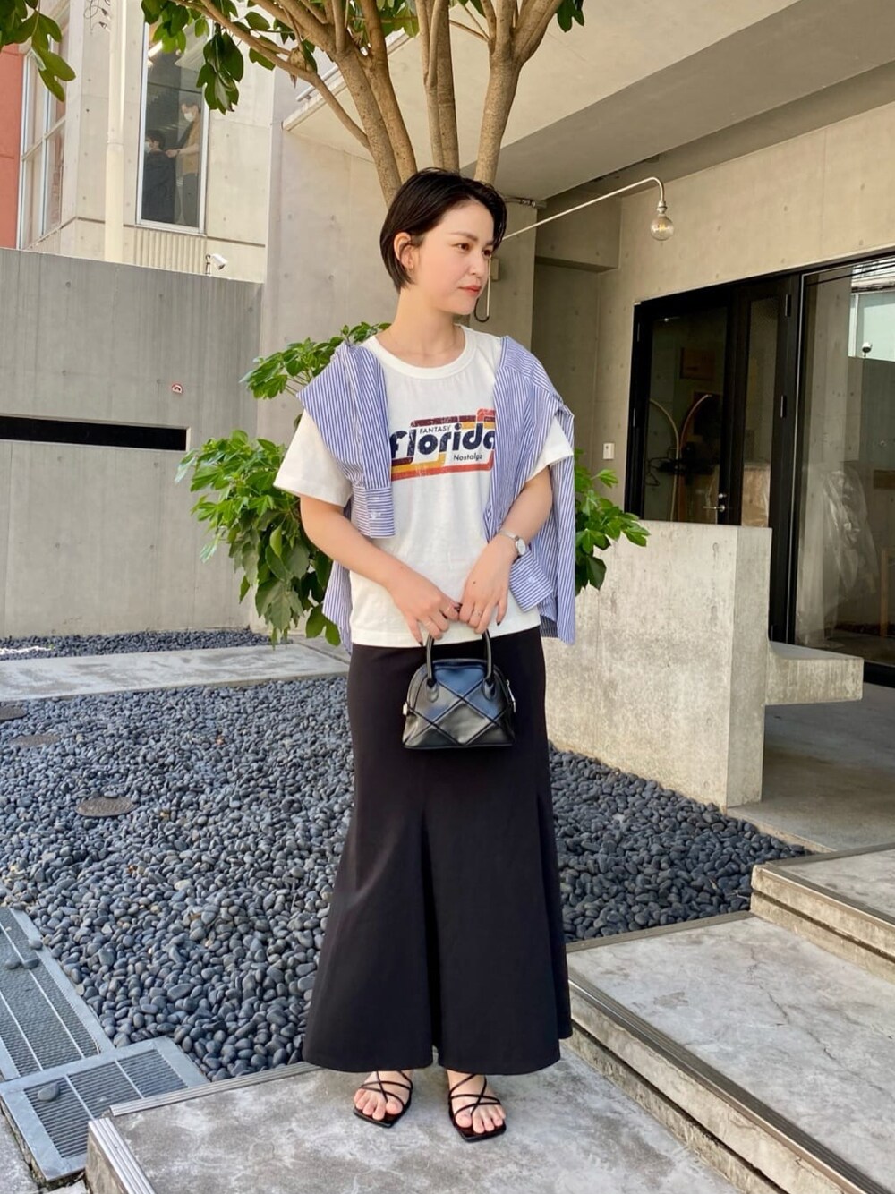 ブルー系のシャツ/ブラウス、ホワイト系のTシャツ/カットソー、ブラック系のショルダーバッグを着用したレディースの春コーディネートの1枚目の写真