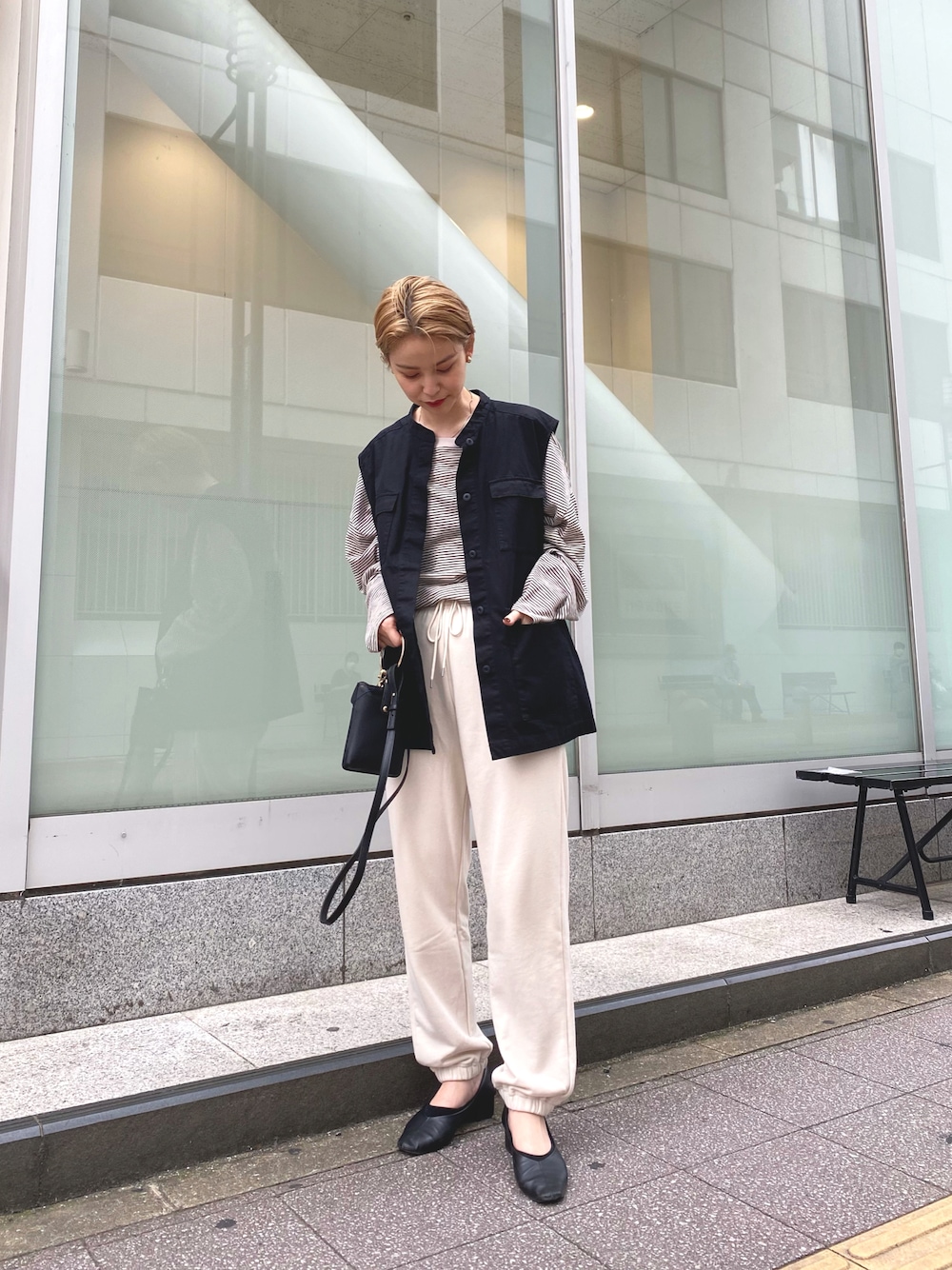 ブラック系のベスト、ホワイト系のTシャツ/カットソー、ブラック系のショルダーバッグを着用したレディースの秋コーディネートの1枚目の写真