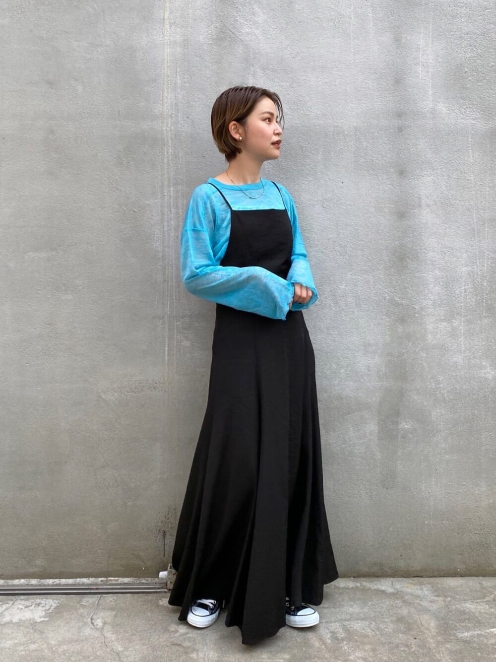 ブラック系のワンピース、ブルー系のTシャツ/カットソーを着用したレディースの春コーディネートの1枚目の写真