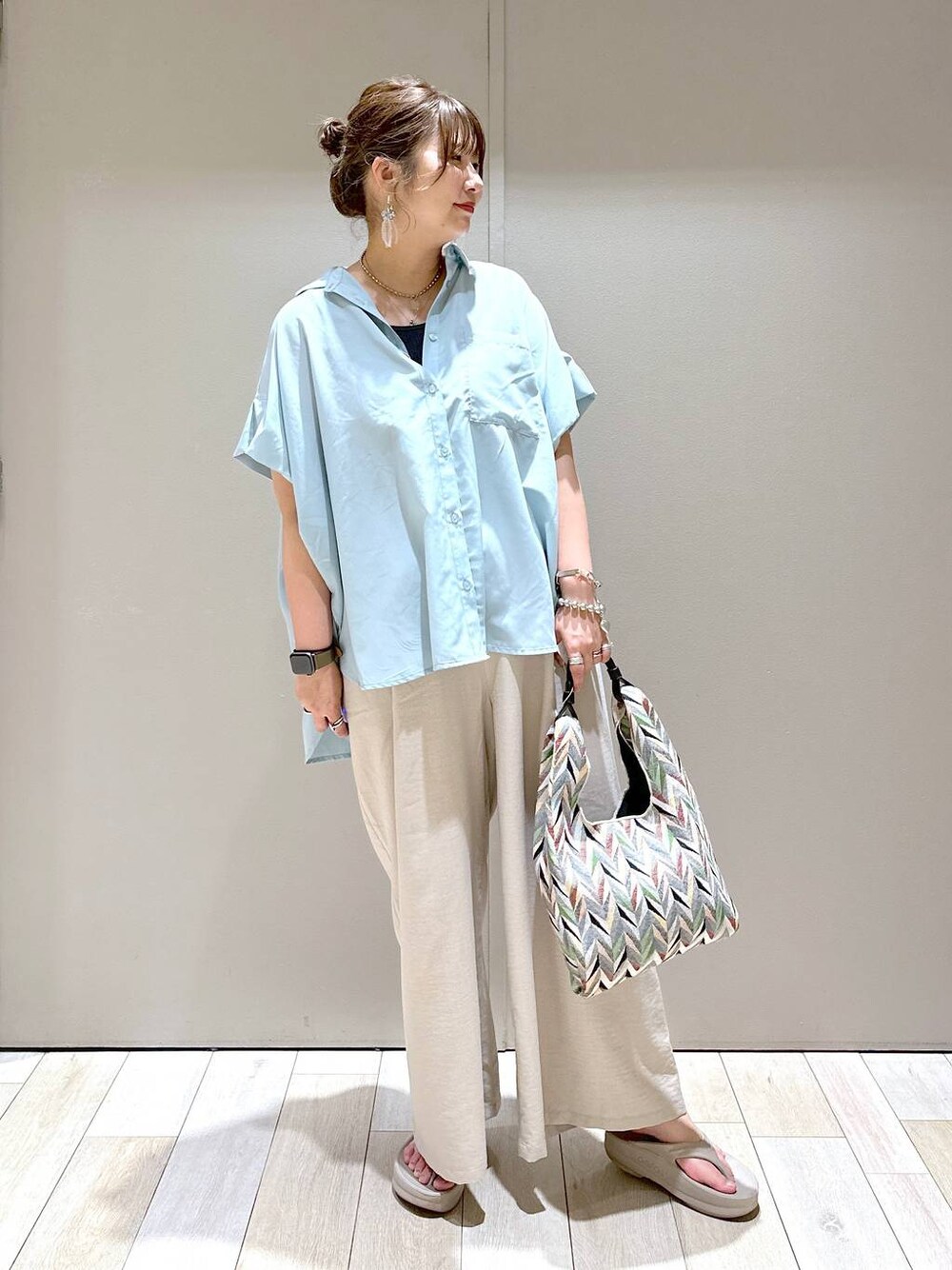 ベージュ系のその他パンツ、ホワイト系のハンドバッグ、ベージュ系のサンダルを着用したレディースの春コーディネートの1枚目の写真