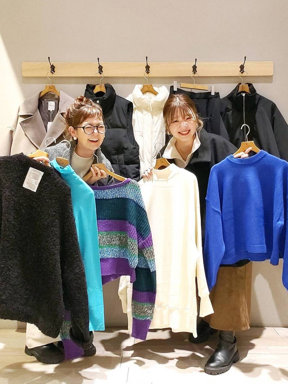 ホワイト系のTシャツ/カットソー、ブラック系のポンチョ、グレー系のチェスターコートを着用したレディースの秋コーディネートの1枚目の写真