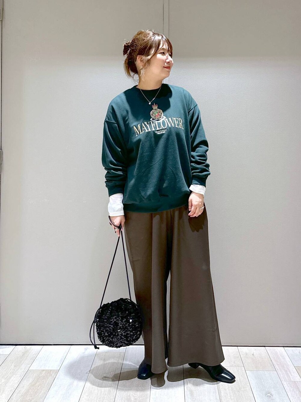 ブラック系のショルダーバッグ、ホワイト系のTシャツ/カットソー、ブラック系のブーツを着用したレディースの秋コーディネートの1枚目の写真