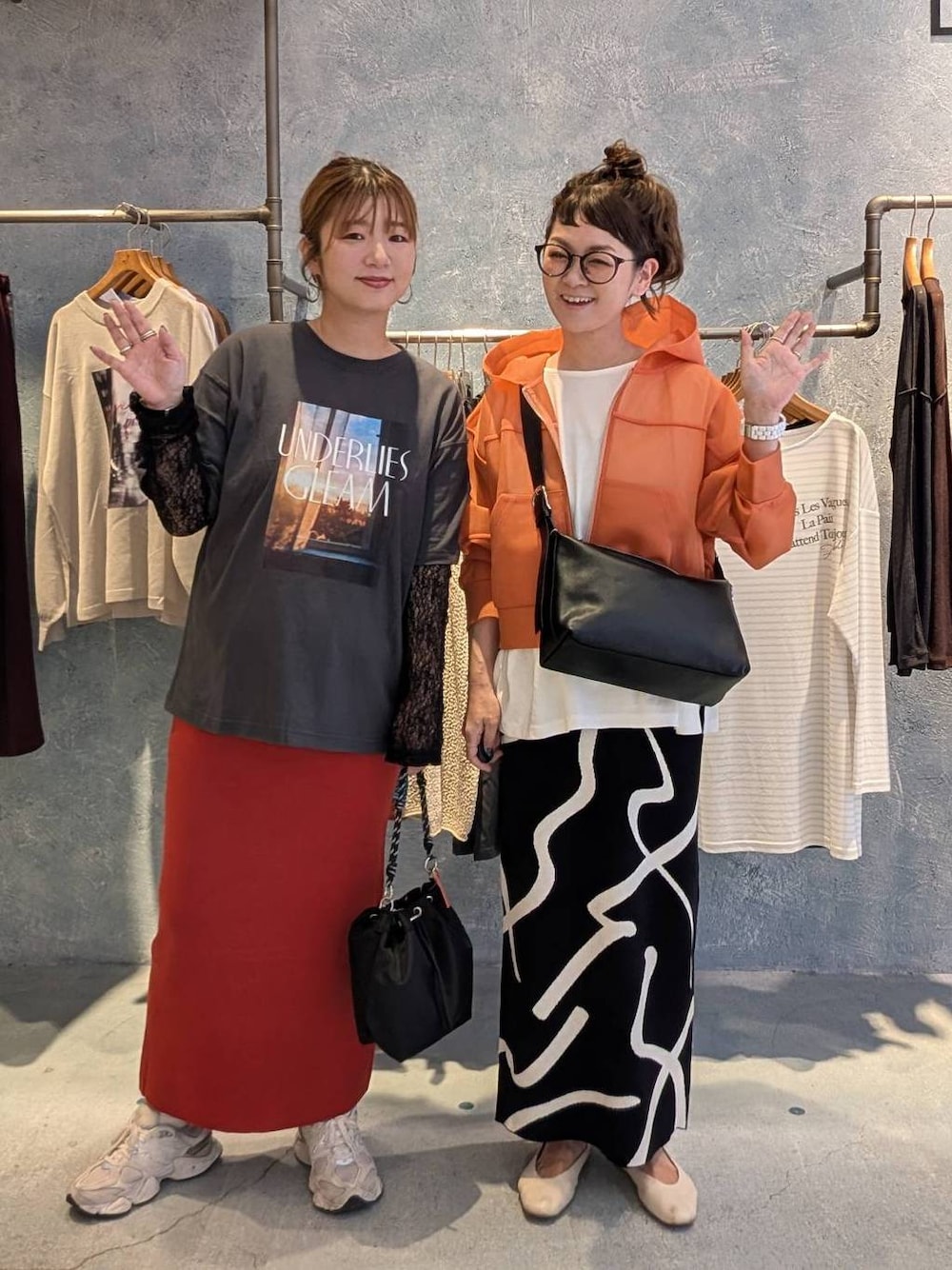 ホワイト系のTシャツ/カットソー、ブラック系のショルダーバッグ、レッド系のスカートを着用したレディースの夏コーディネートの1枚目の写真