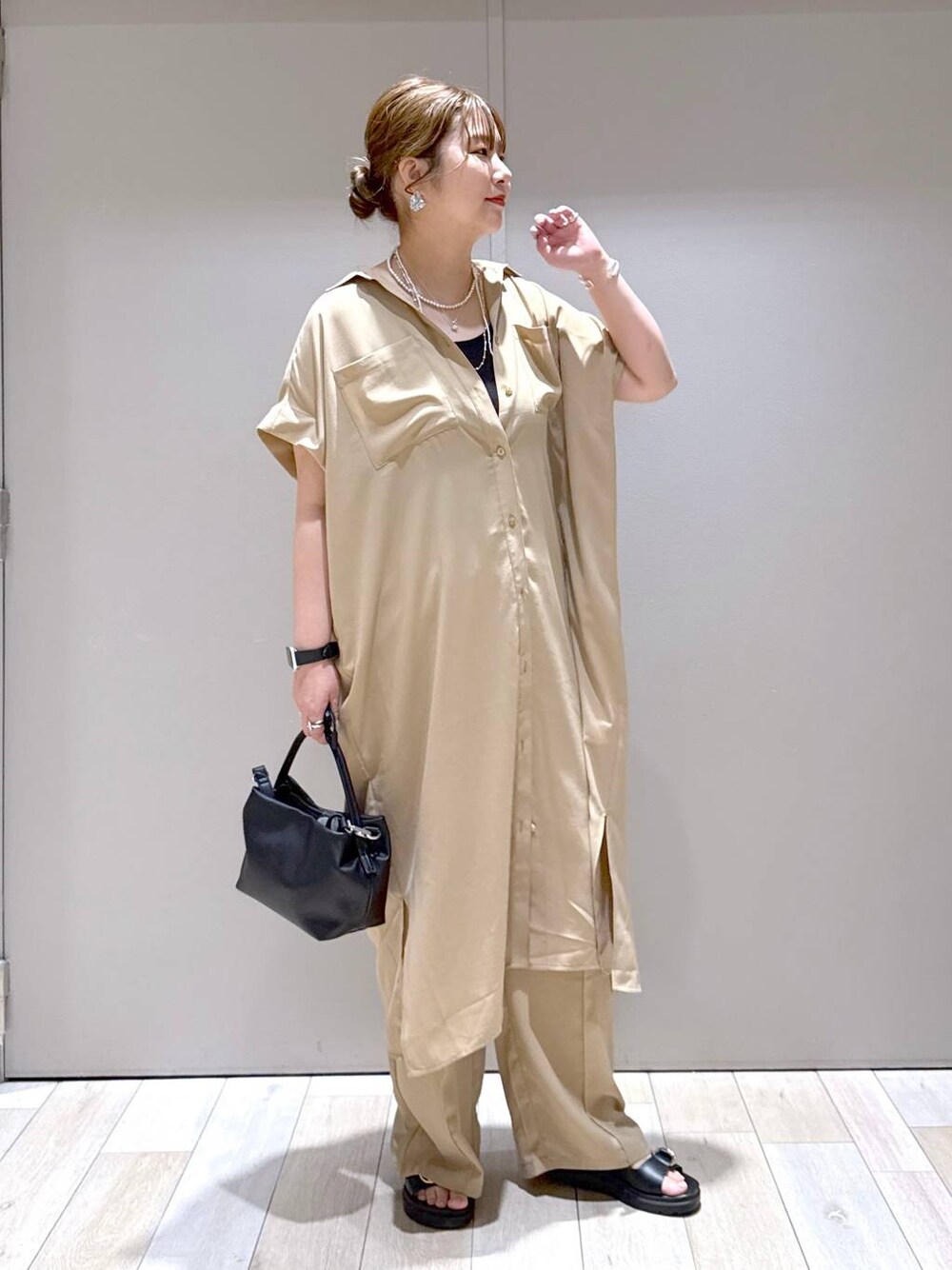 ベージュ系のその他パンツ、ベージュ系のワンピース、ブラック系のサンダルを着用したレディースの春コーディネートの1枚目の写真