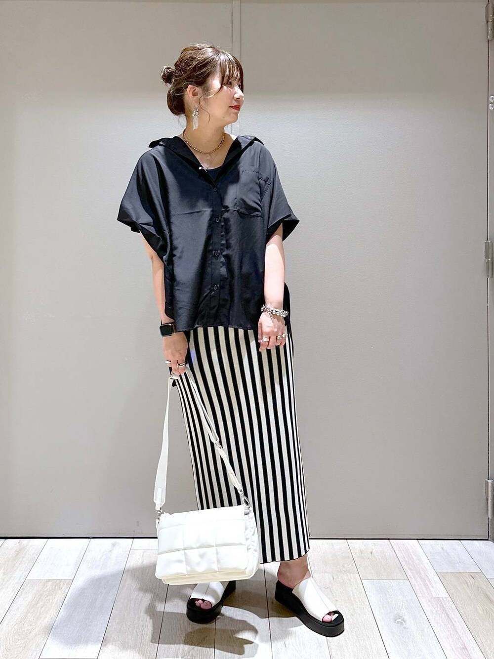 ホワイト系のショルダーバッグ、ブラック系のシャツ/ブラウス、ホワイト系のスカートを着用したレディースの春コーディネートの1枚目の写真