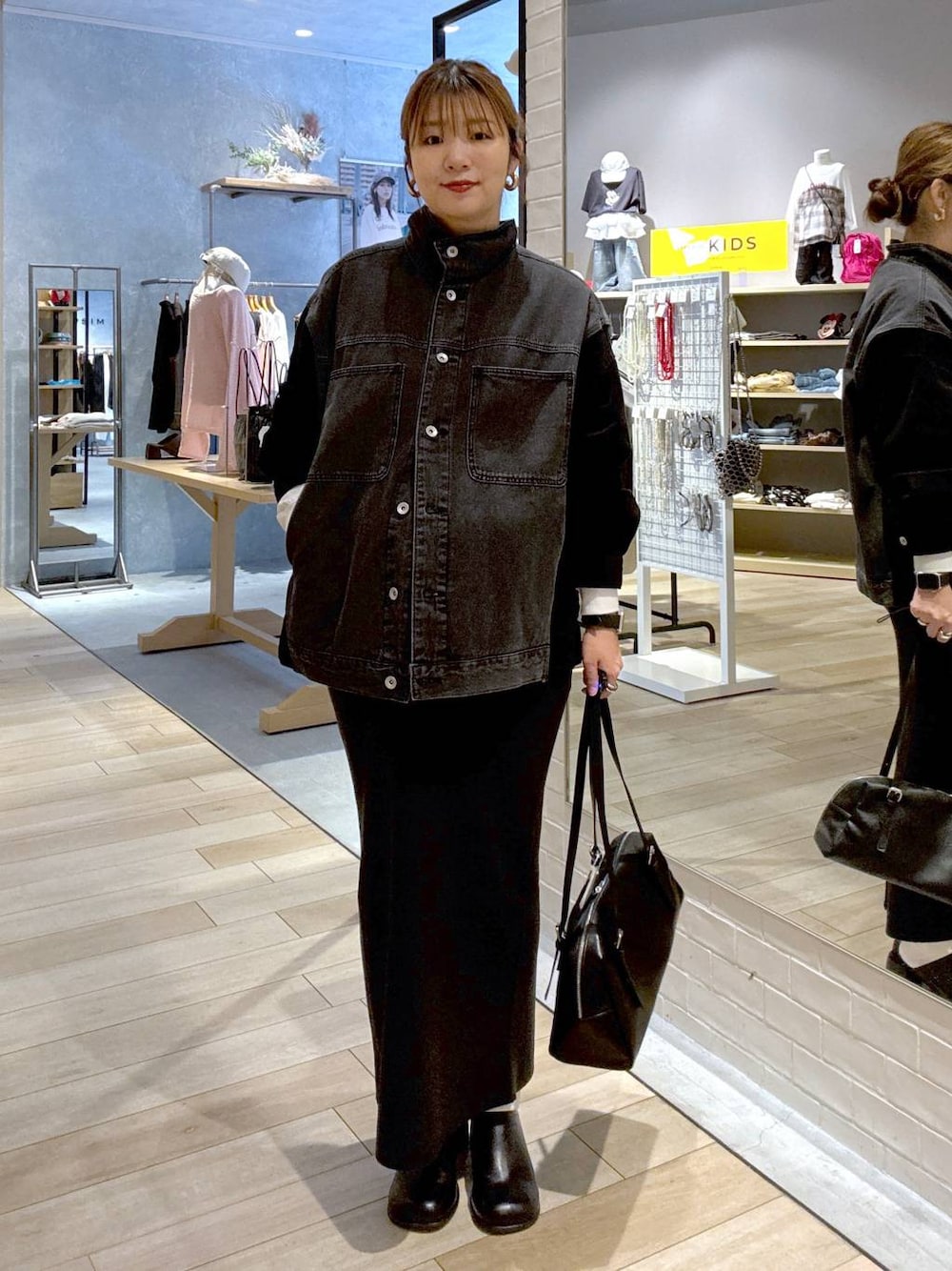 ブラック系のスカート、ブラック系のその他シューズ、ブラック系のボストンバッグを着用したレディースの秋コーディネートの1枚目の写真