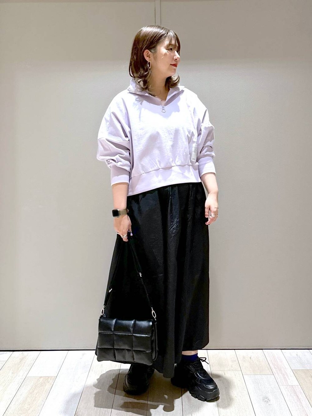 ブラック系のスニーカー、ブラック系のショルダーバッグ、ブラック系のスカートを着用したレディースの春コーディネートの1枚目の写真