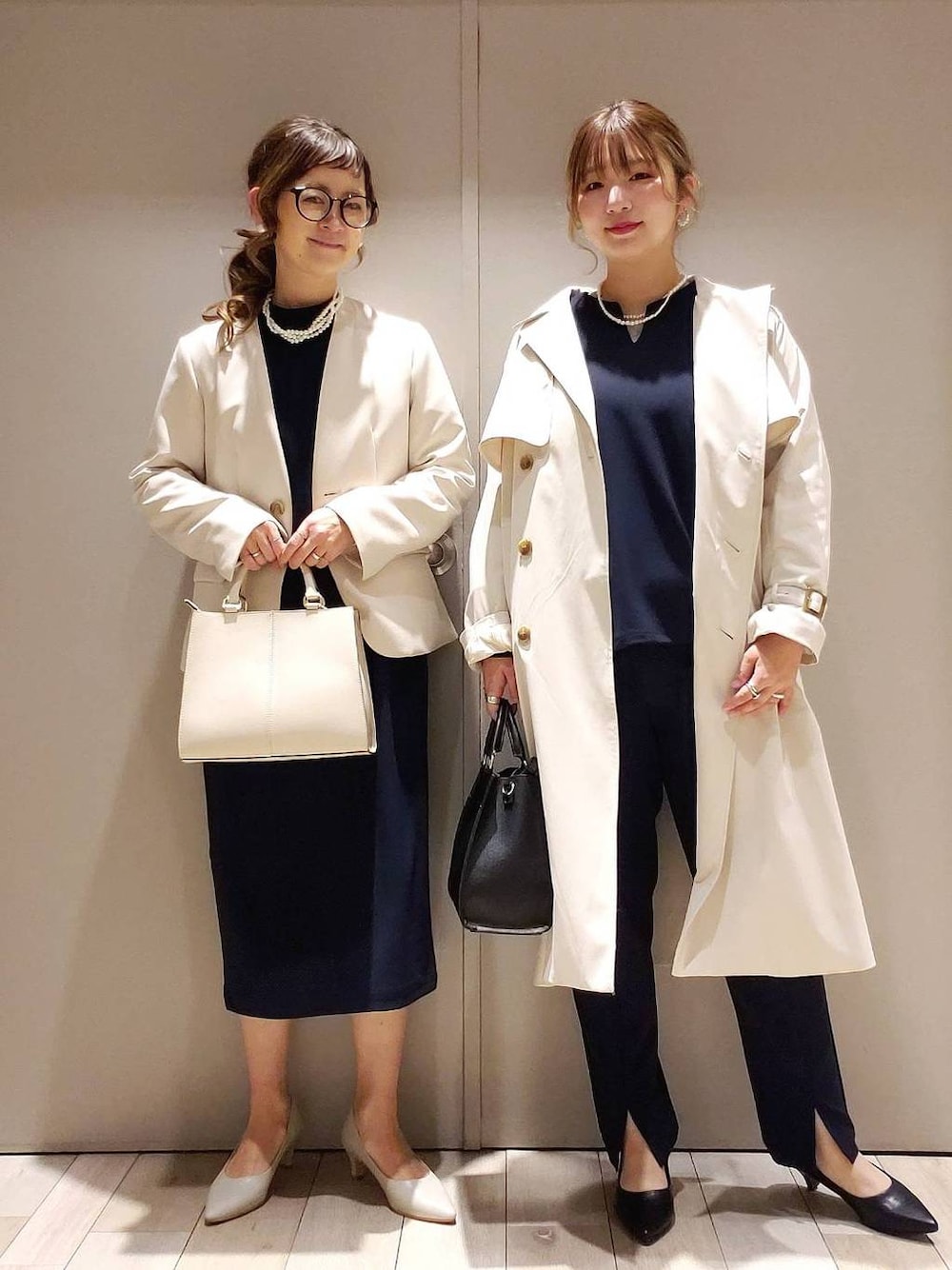ベージュ系のトレンチコート、ブルー系のスラックス、ブルー系のワンピースを着用したレディースの冬コーディネートの1枚目の写真