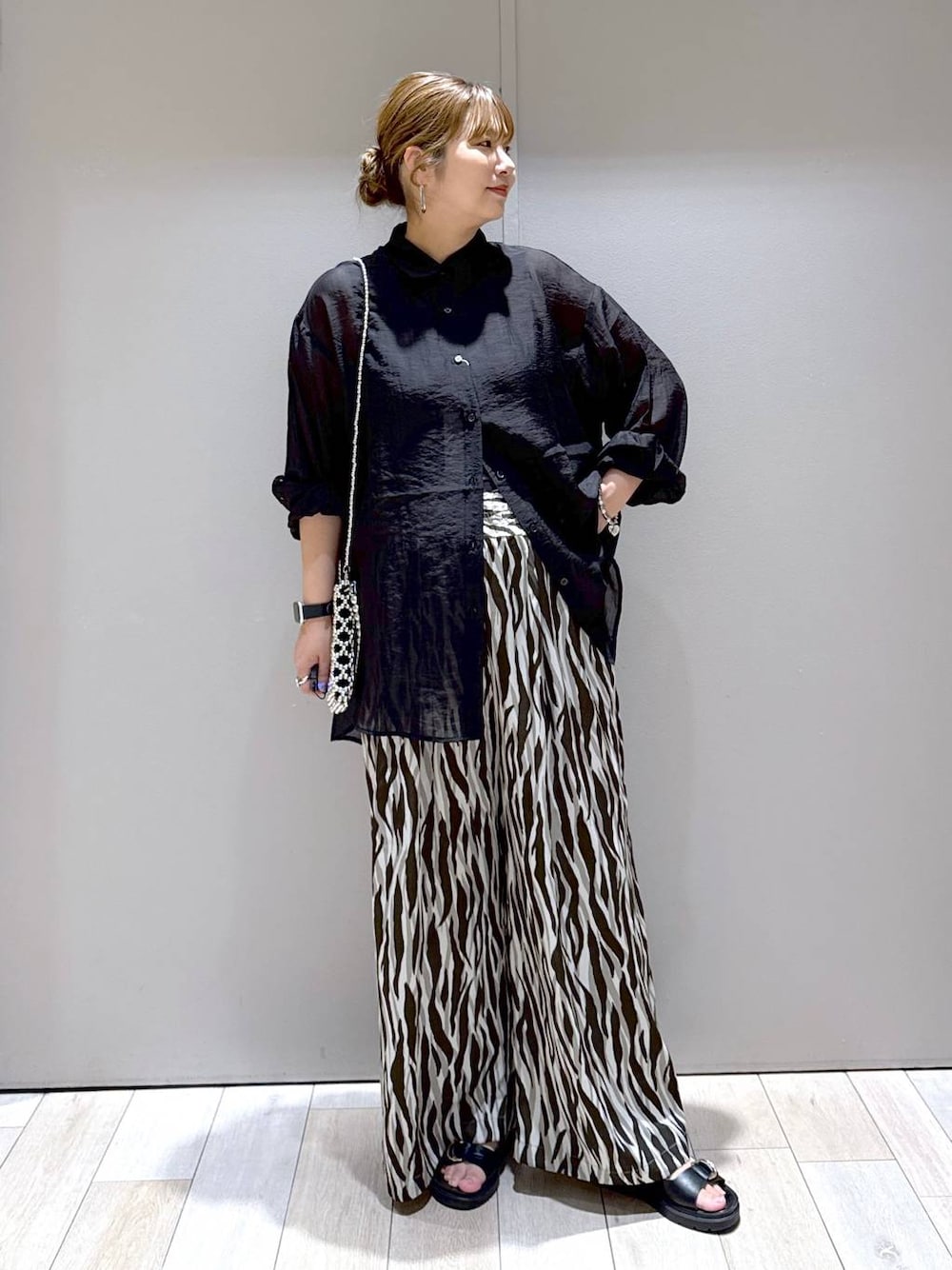 ブラック系のサンダル、シルバー系のショルダーバッグ、ブラック系のシャツ/ブラウスを着用したレディースの夏コーディネートの1枚目の写真