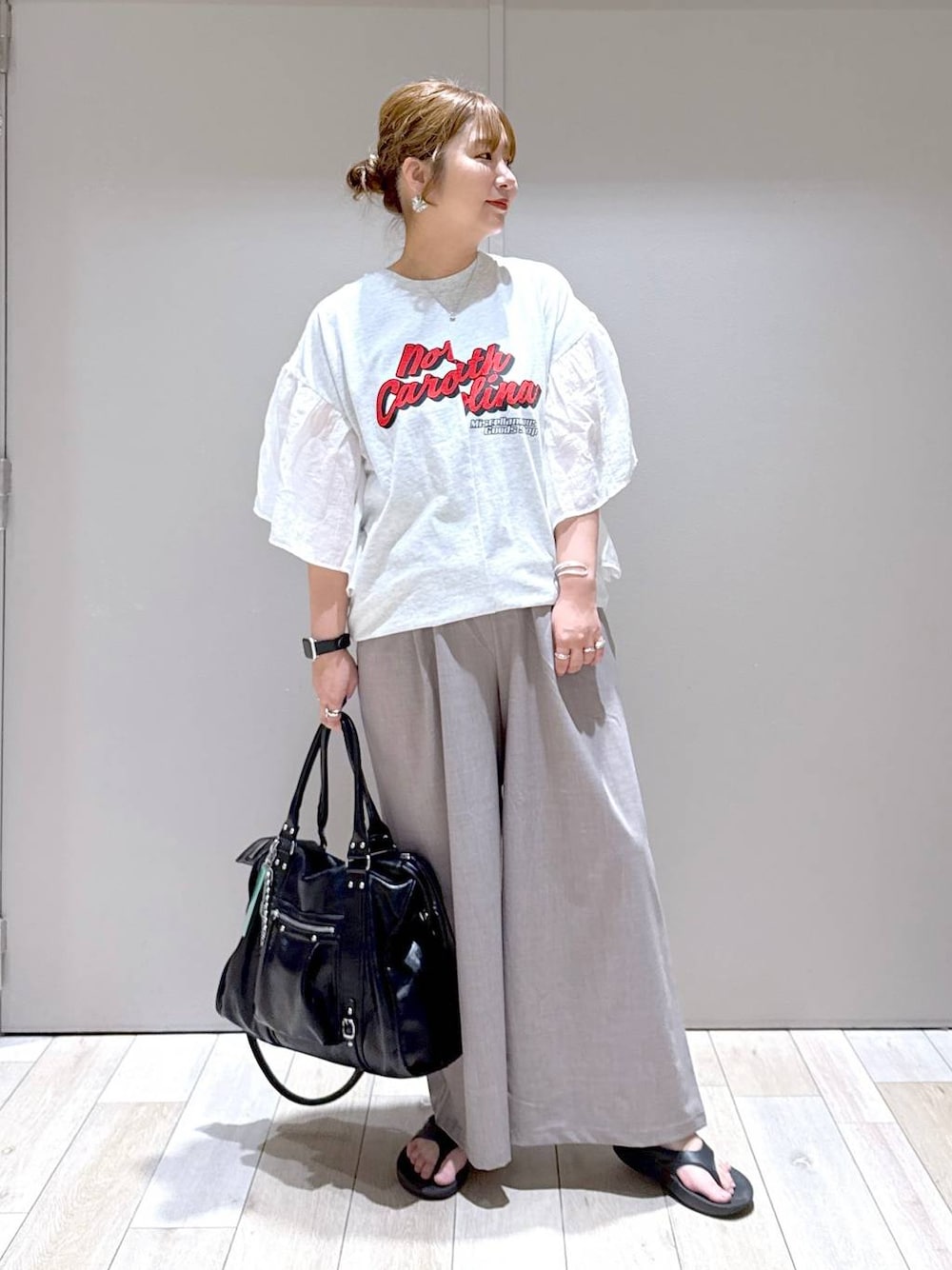 ブラック系のトートバッグ、ベージュ系のその他パンツ、ブラック系のサンダルを着用したレディースの春コーディネートの1枚目の写真