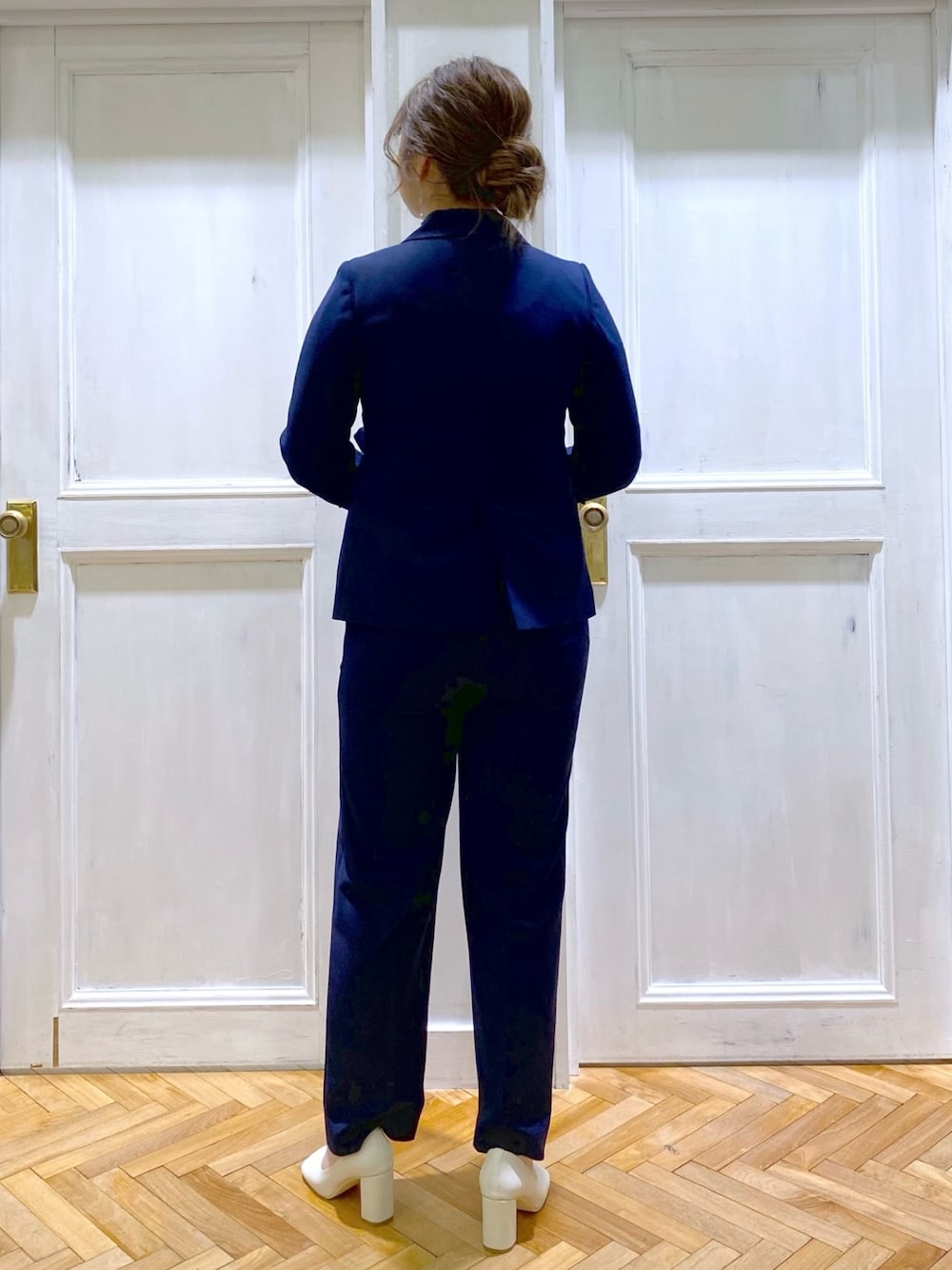 ベージュ系のTシャツ/カットソー、ブルー系のテーラードジャケット、ブルー系のスラックスを着用したレディースの冬コーディネートの3枚目の写真