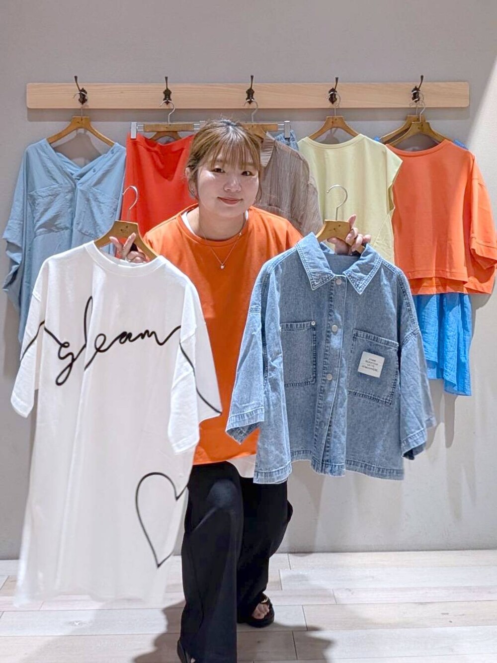 オレンジ系のスカート、ベージュ系のシャツ/ブラウス、オレンジ系のTシャツ/カットソーを着用したレディースの春コーディネートの1枚目の写真