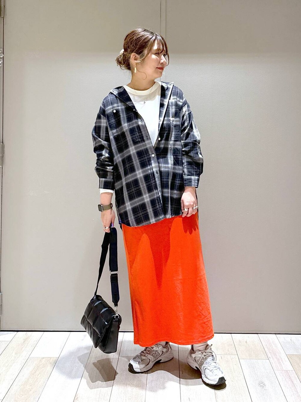 ブラック系のショルダーバッグ、ブラック系のシャツ/ブラウス、レッド系のスカートを着用したレディースの春コーディネートの1枚目の写真