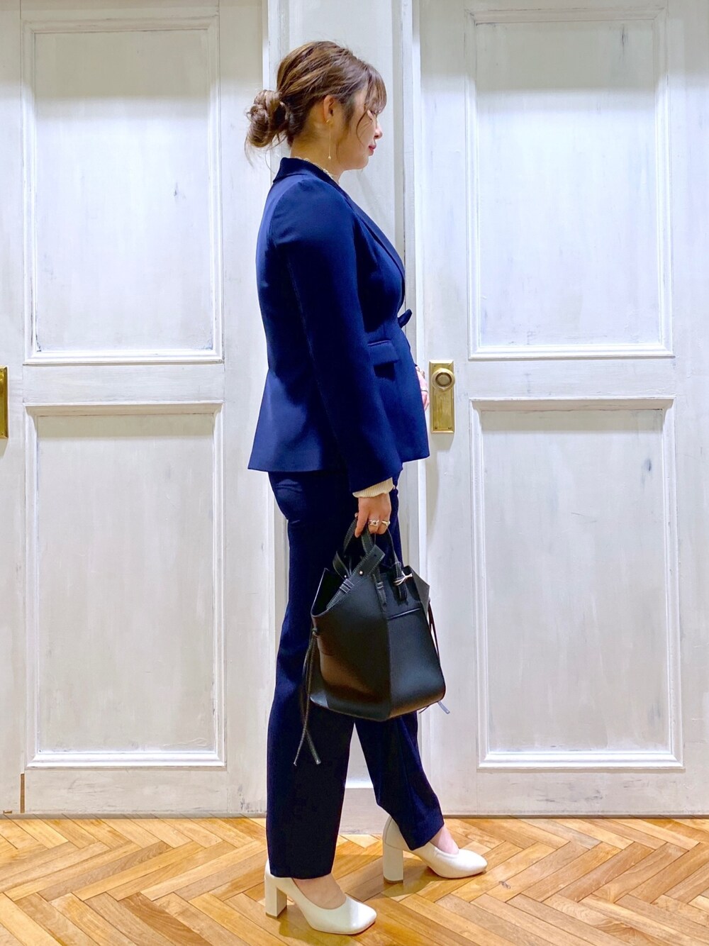 ベージュ系のTシャツ/カットソー、ブルー系のテーラードジャケット、ブルー系のスラックスを着用したレディースの冬コーディネートの2枚目の写真