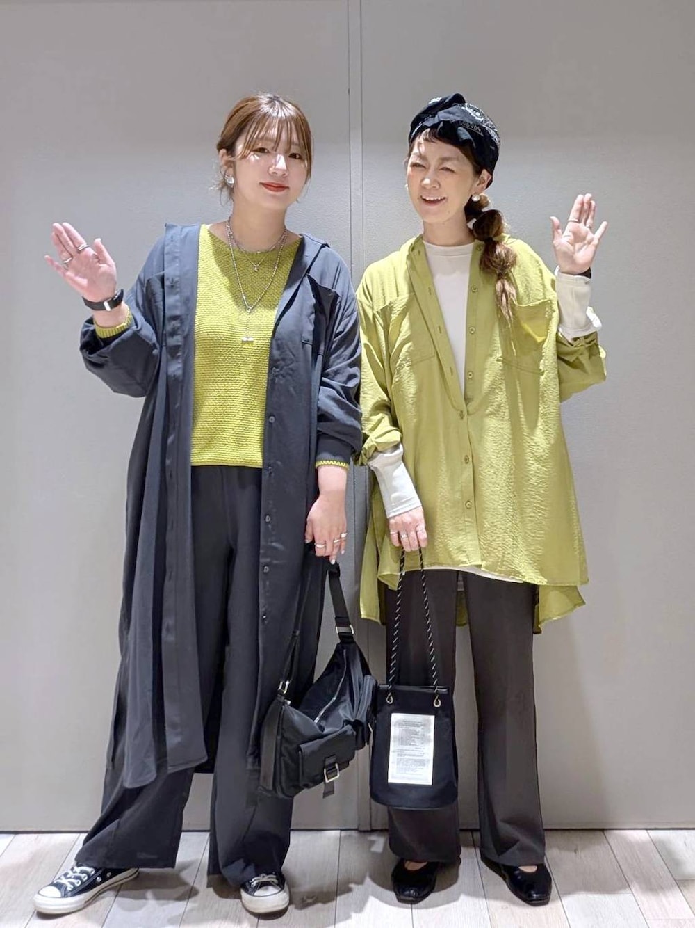 グレー系のスラックス、グリーン系のシャツ/ブラウス、グレー系のワンピースを着用したレディースの春コーディネートの1枚目の写真