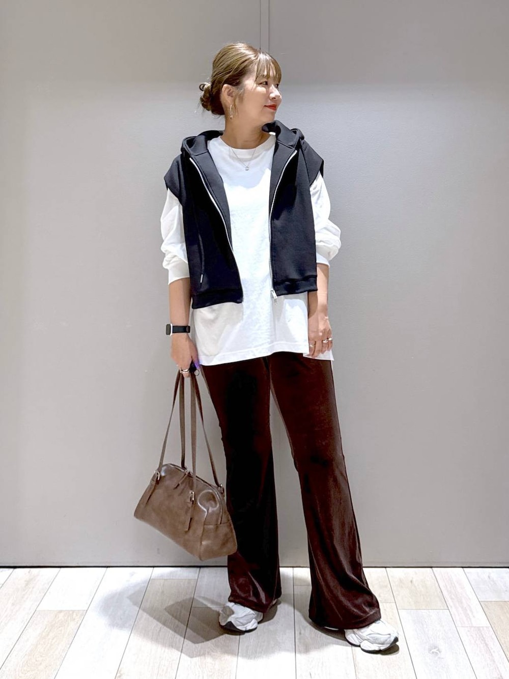 ブラウン系のその他パンツ、ブラウン系のボストンバッグ、ブラック系のベストを着用したレディースの秋コーディネートの1枚目の写真
