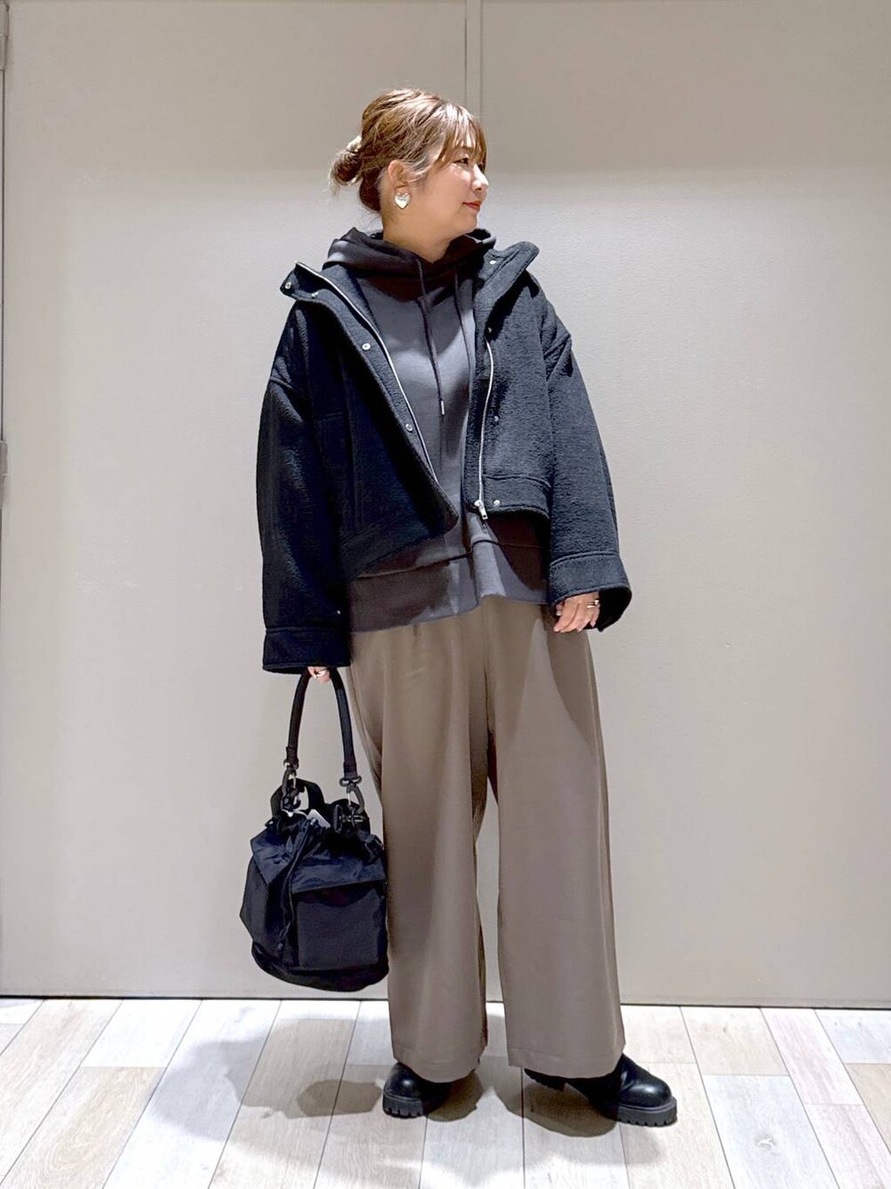 ブラック系のショルダーバッグ、ブラック系のブルゾン、ブラウン系のその他パンツを着用したレディースの冬コーディネートの1枚目の写真