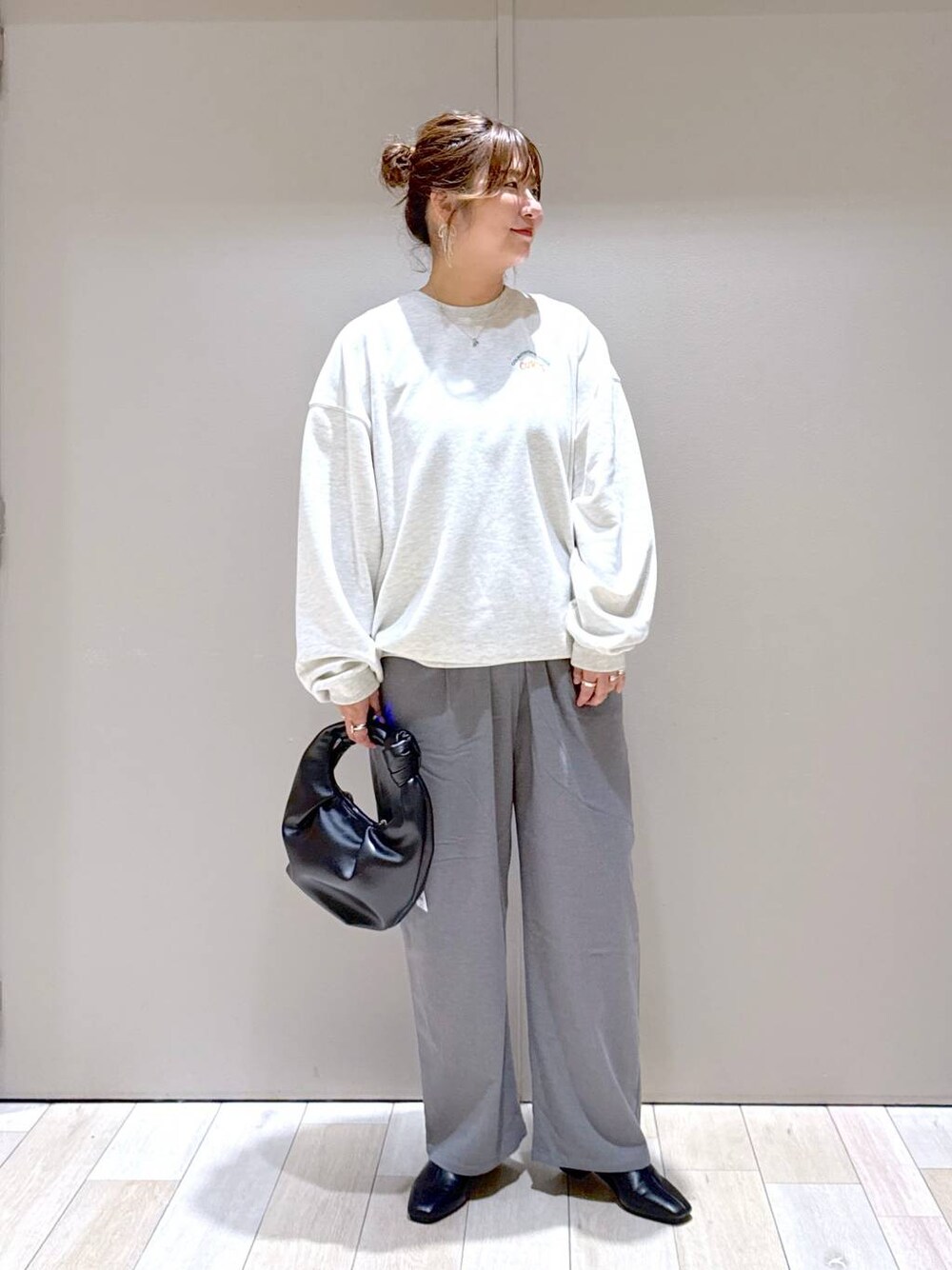ブラック系のブーツ、グレー系のその他パンツ、ベージュ系のスウェットを着用したレディースの冬コーディネートの1枚目の写真