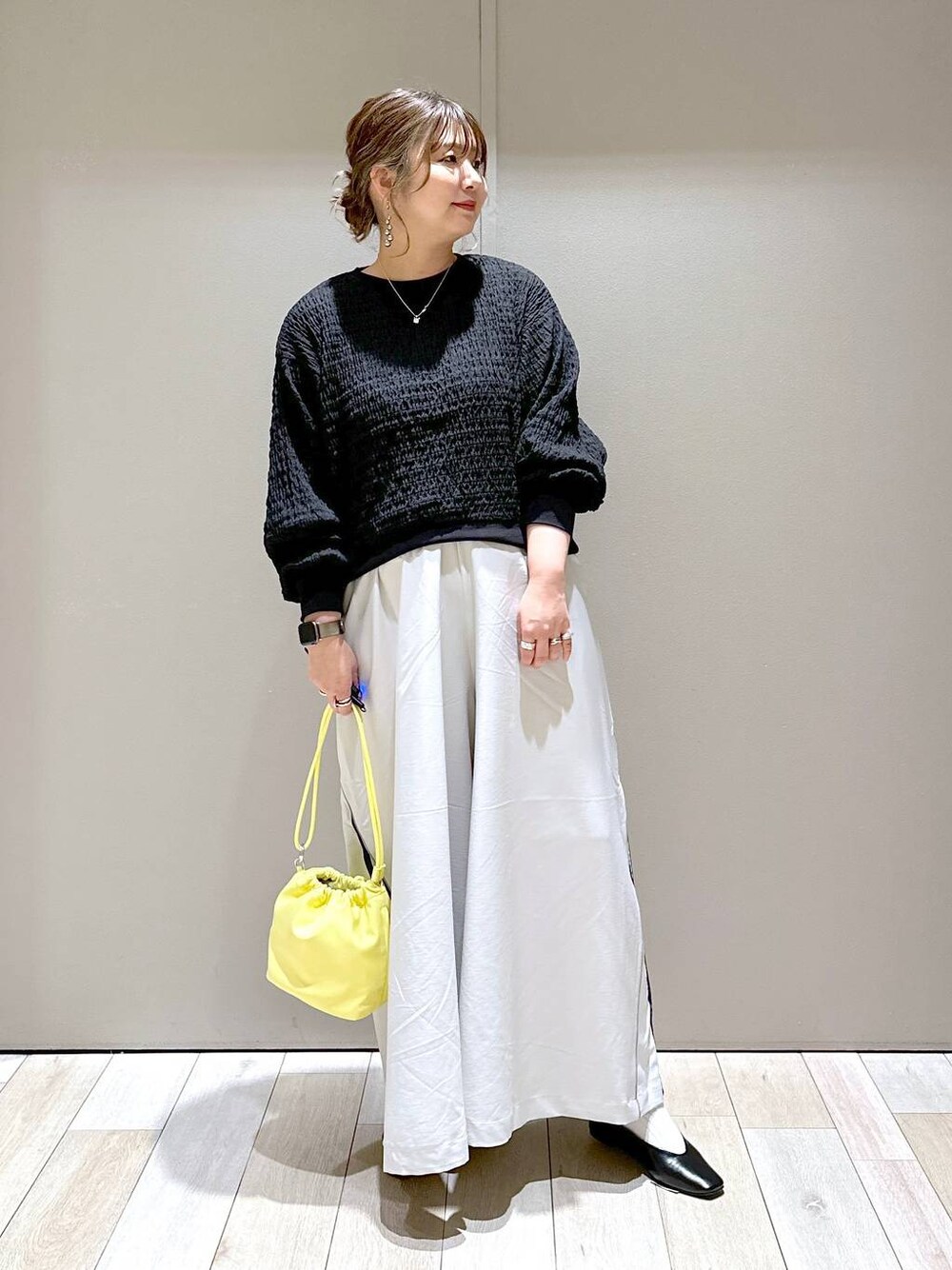 ブラック系のTシャツ/カットソー、ブラック系のパンプス、イエロー系のショルダーバッグを着用したレディースの春コーディネートの1枚目の写真