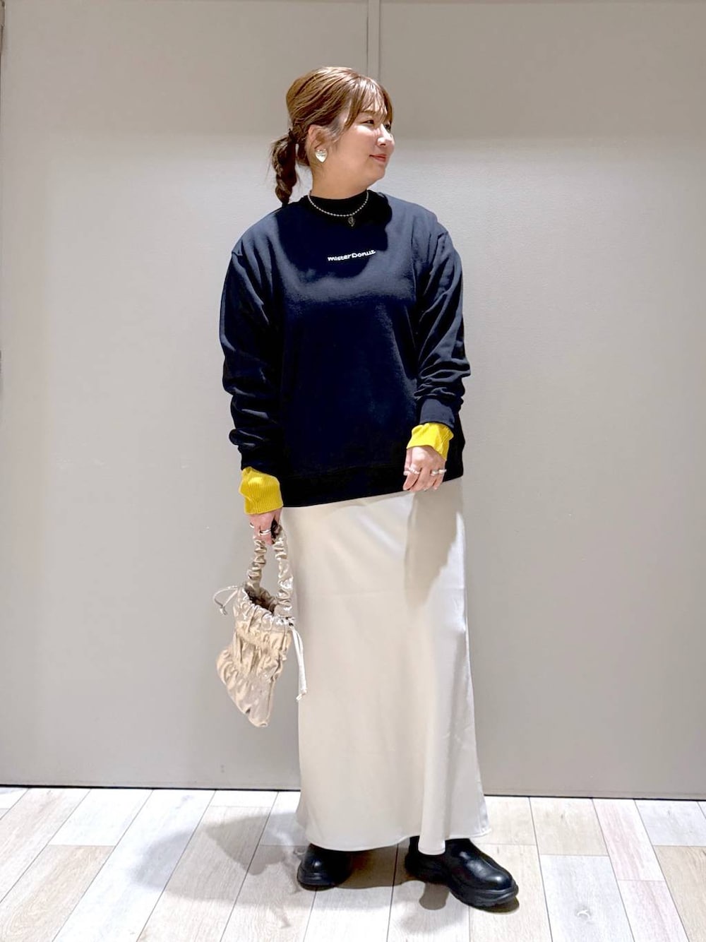 ブラック系のニット/セーター、ホワイト系のスカート、ブラック系のブーツを着用したレディースの冬コーディネートの1枚目の写真