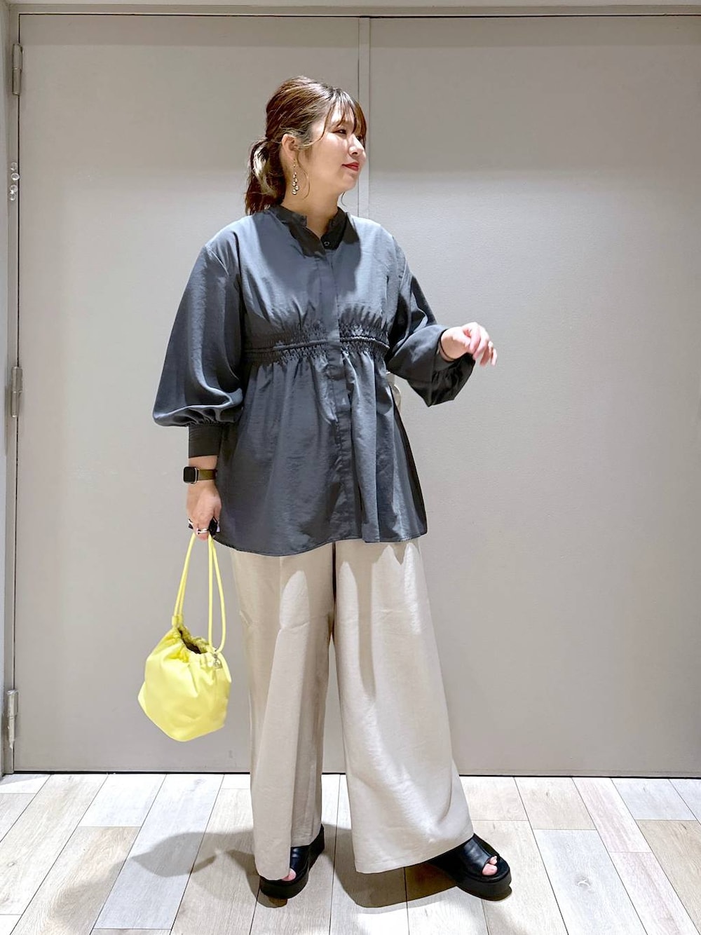 グレー系のシャツ/ブラウス、イエロー系のショルダーバッグ、ブラック系のサンダルを着用したレディースの春コーディネートの1枚目の写真
