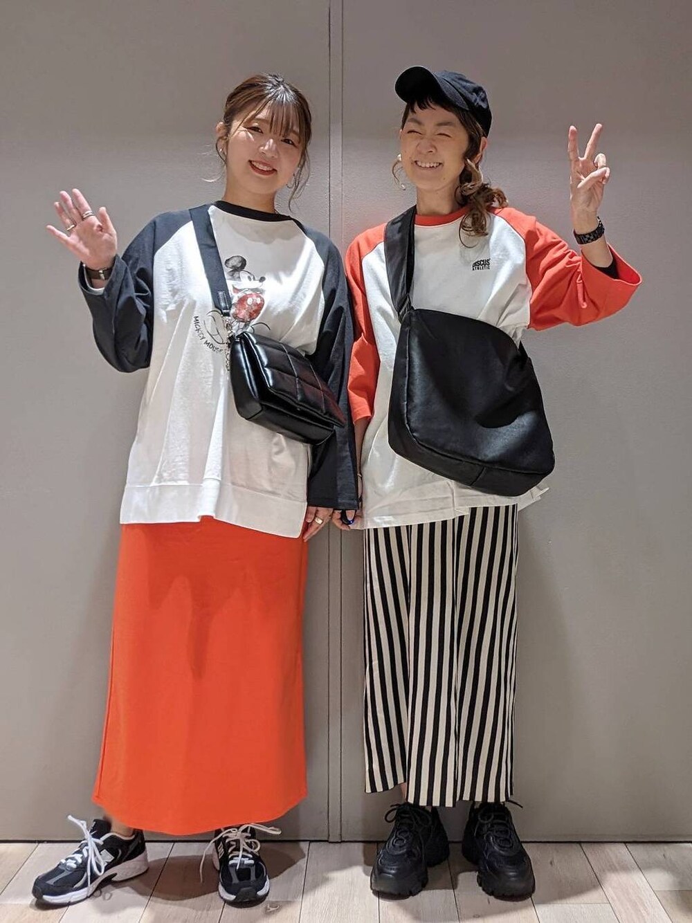 ブラック系のスニーカー、ブラック系のショルダーバッグ、レッド系のTシャツ/カットソーを着用したレディースの春コーディネートの1枚目の写真