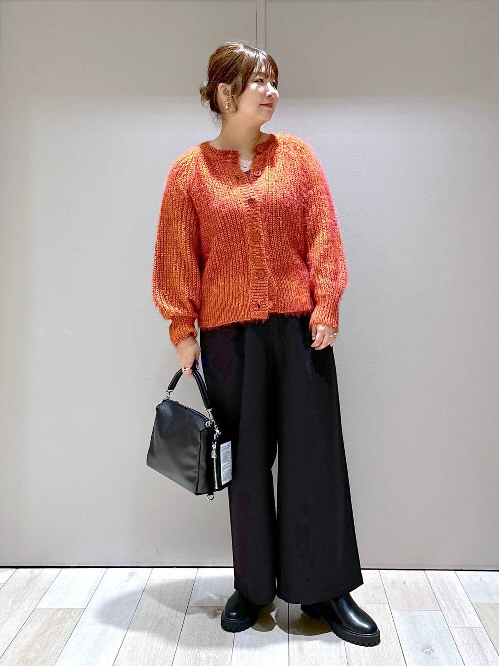 ブラック系のその他パンツ、レッド系のカーディガン/ボレロ、ブラック系のブーツを着用したレディースの秋コーディネートの1枚目の写真
