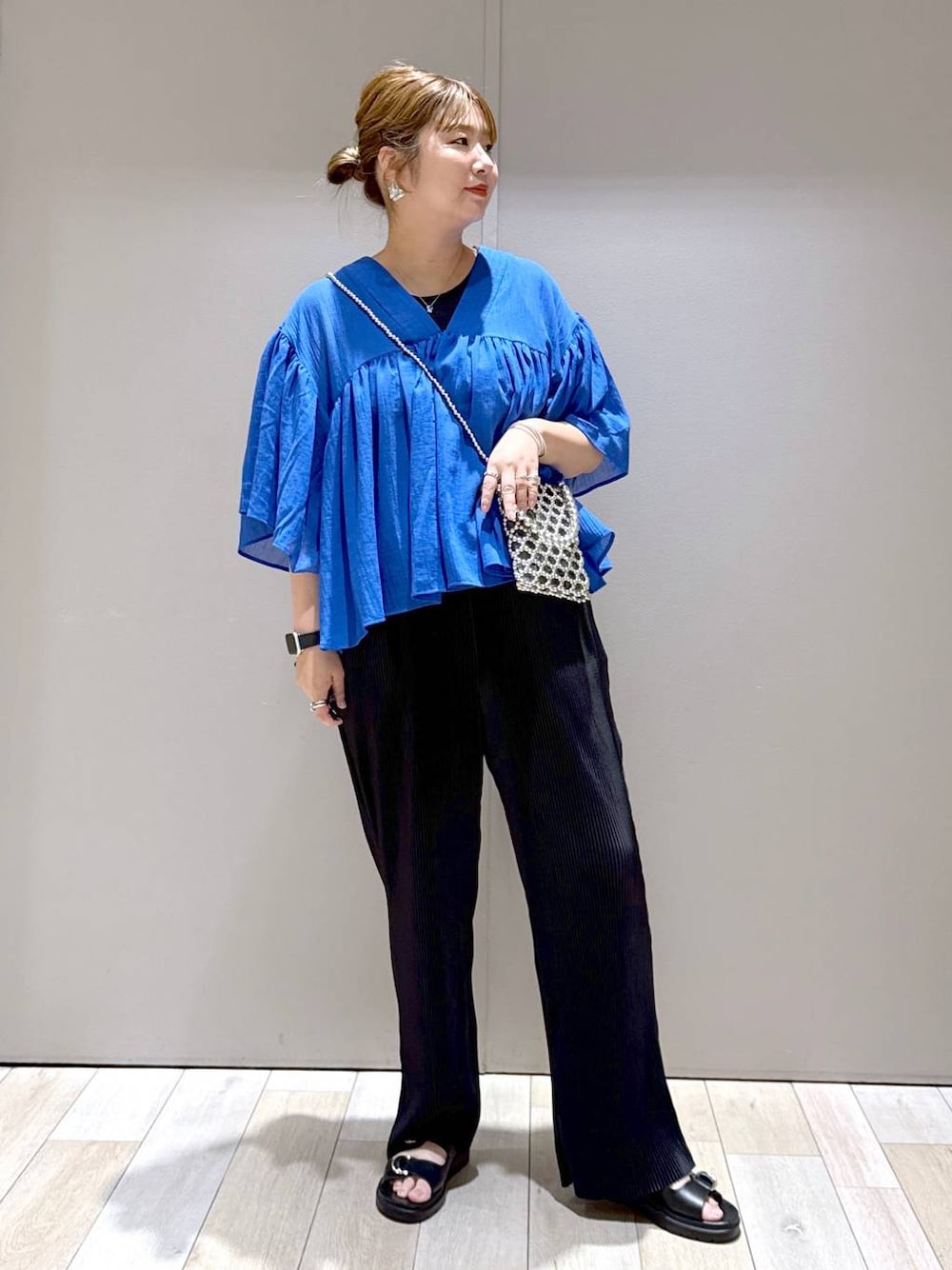 ブルー系のシャツ/ブラウス、ブラック系のTシャツ/カットソー、ブラック系のサンダルを着用したレディースの春コーディネートの1枚目の写真