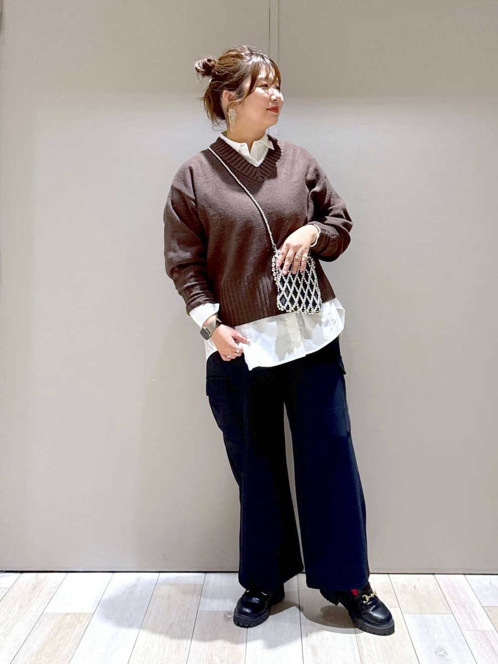 ブラウン系のニット/セーター、ブラック系のローファー、ホワイト系のシャツ/ブラウスを着用したレディースの冬コーディネートの1枚目の写真