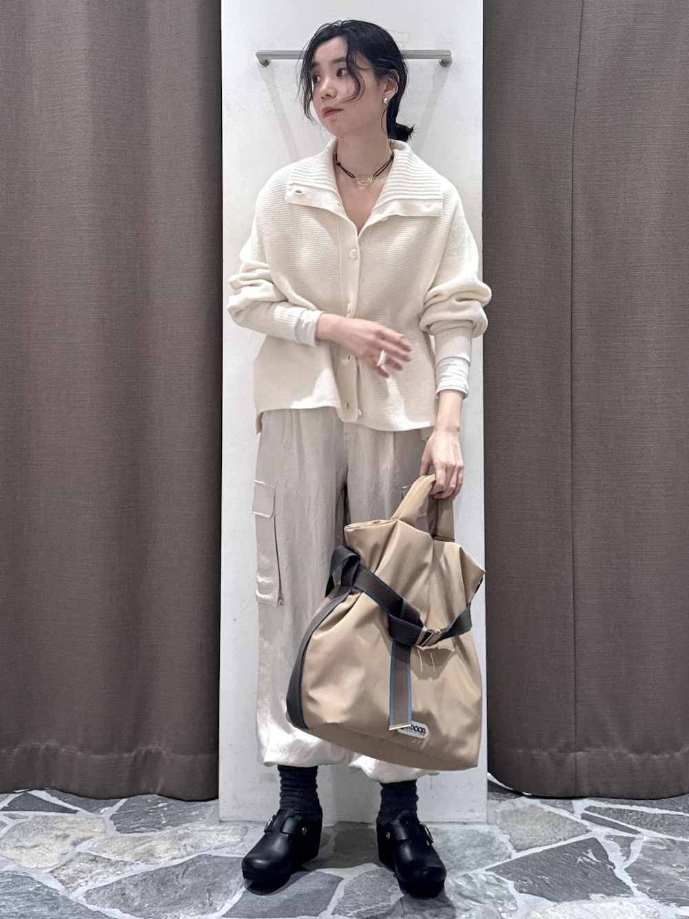 ホワイト系のカーディガン/ボレロ、ホワイト系のカーゴパンツ、ベージュ系のトートバッグを着用したレディースの冬コーディネートの1枚目の写真