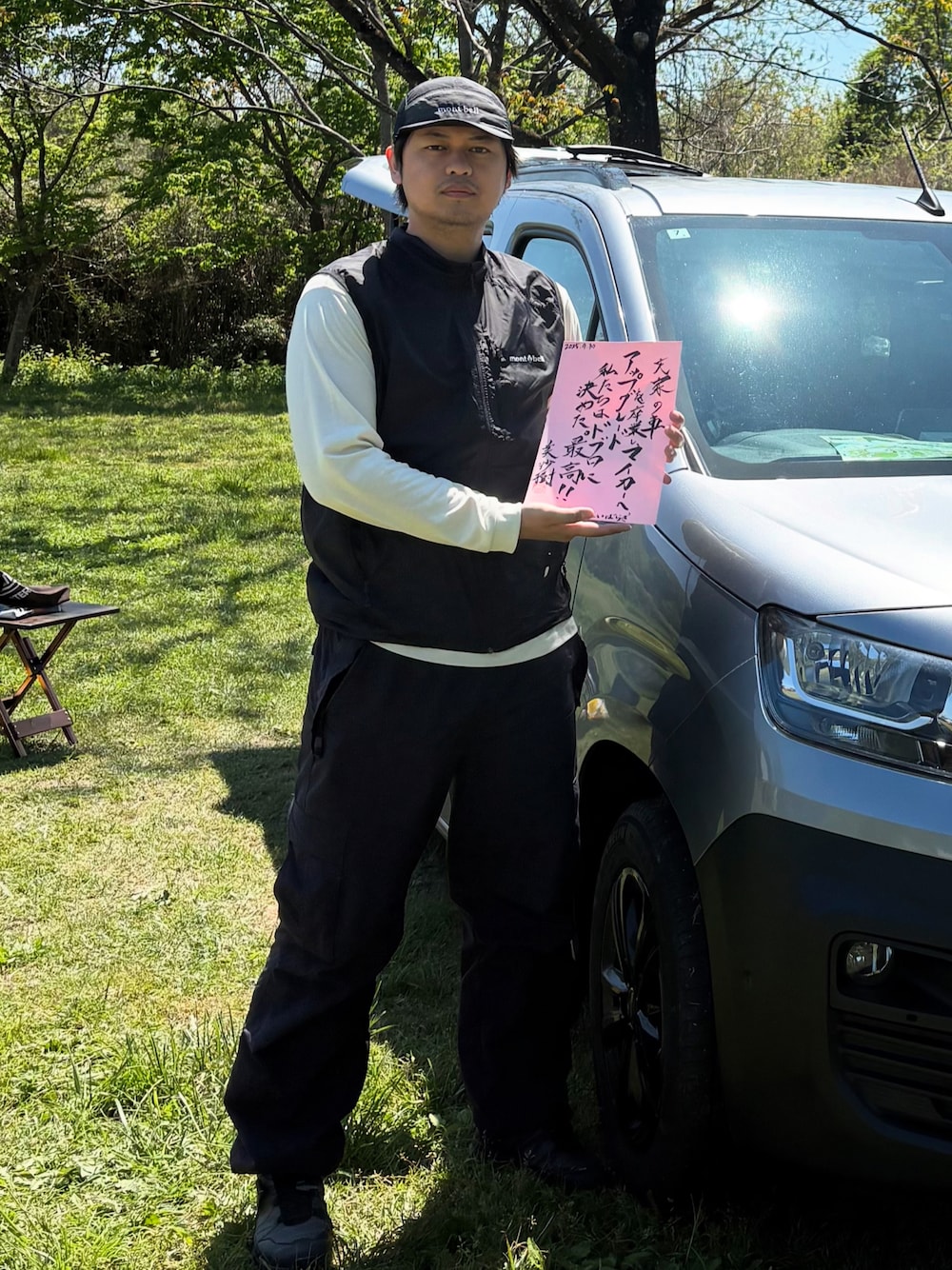 ブラック系のベスト、ブルー系のカーゴパンツ、グレー系のシューズを着用したメンズの夏コーディネートの1枚目の写真