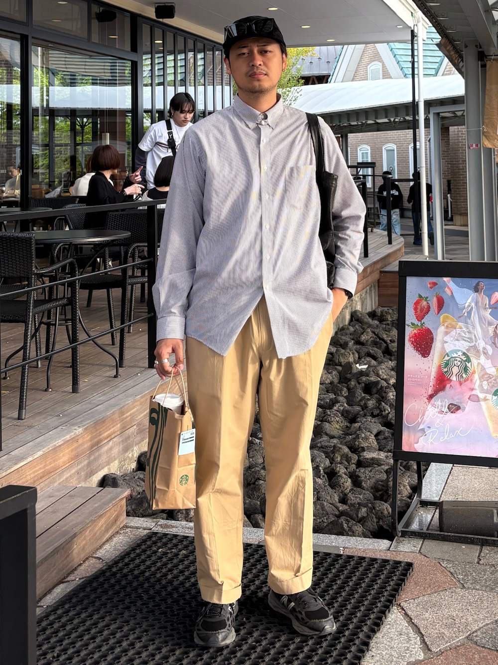 ブルー系のシャツ/ブラウス、イエロー系のチノパンツ、ブラック系のスニーカーを着用したメンズの春コーディネートの1枚目の写真