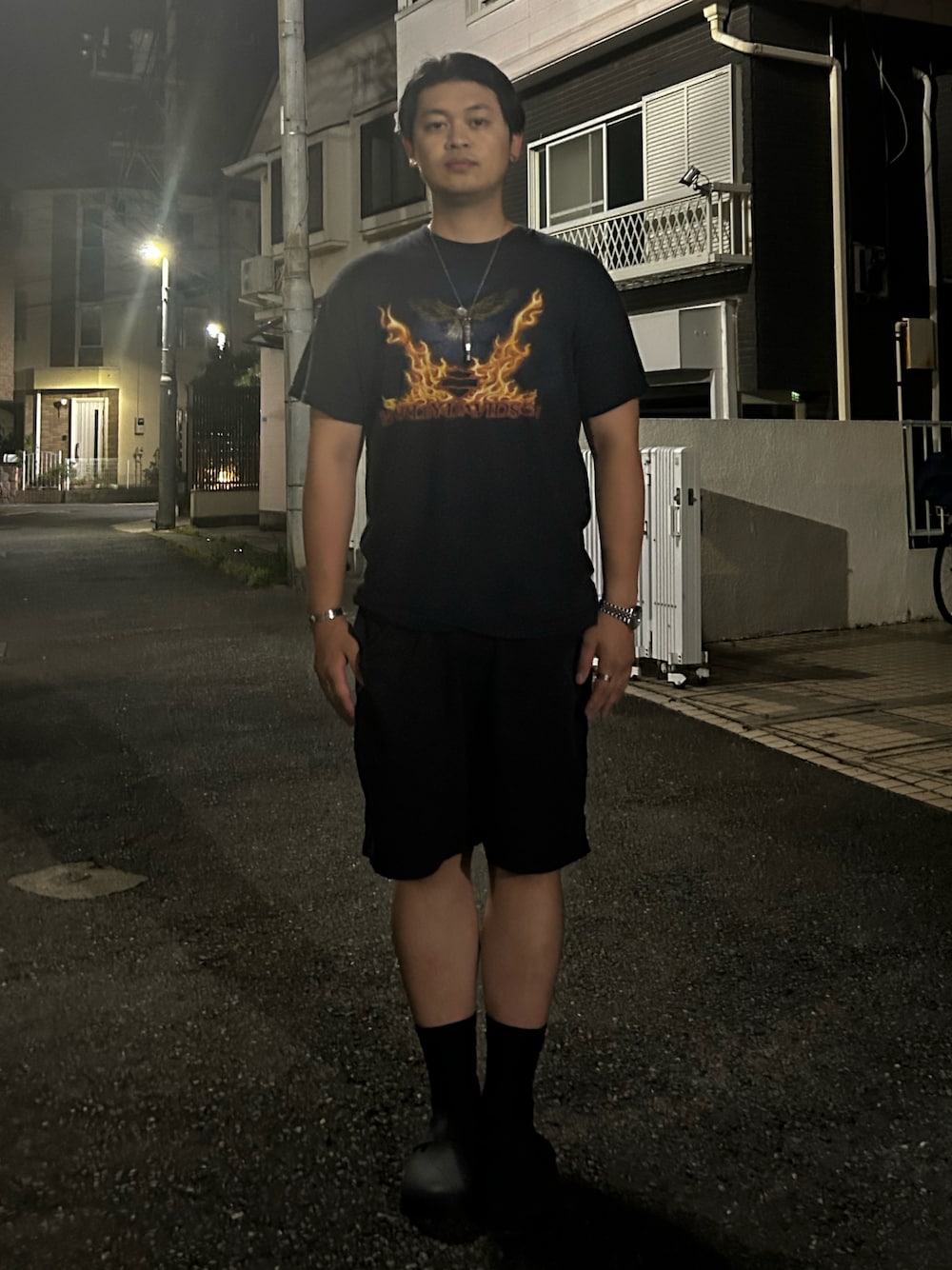 ブラック系のTシャツ/カットソー、ブラック系のチノパンツ、ブラック系のサンダルを着用したメンズの秋コーディネートの1枚目の写真