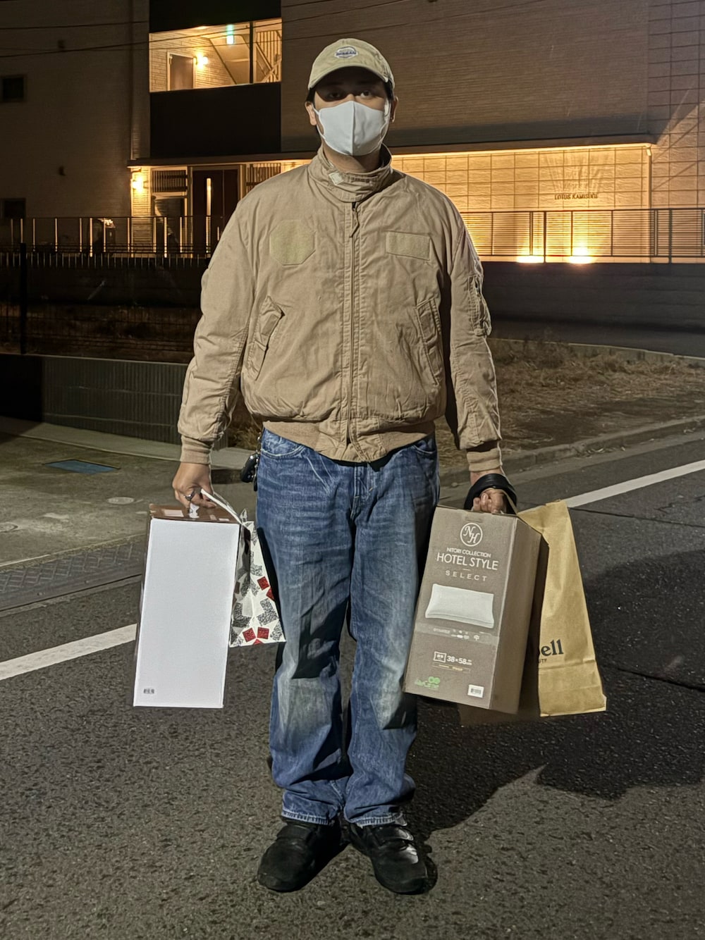 ベージュ系のミリタリージャケット、ブルー系のデニムパンツ、ブラック系のシューズを着用したメンズの冬コーディネートの1枚目の写真