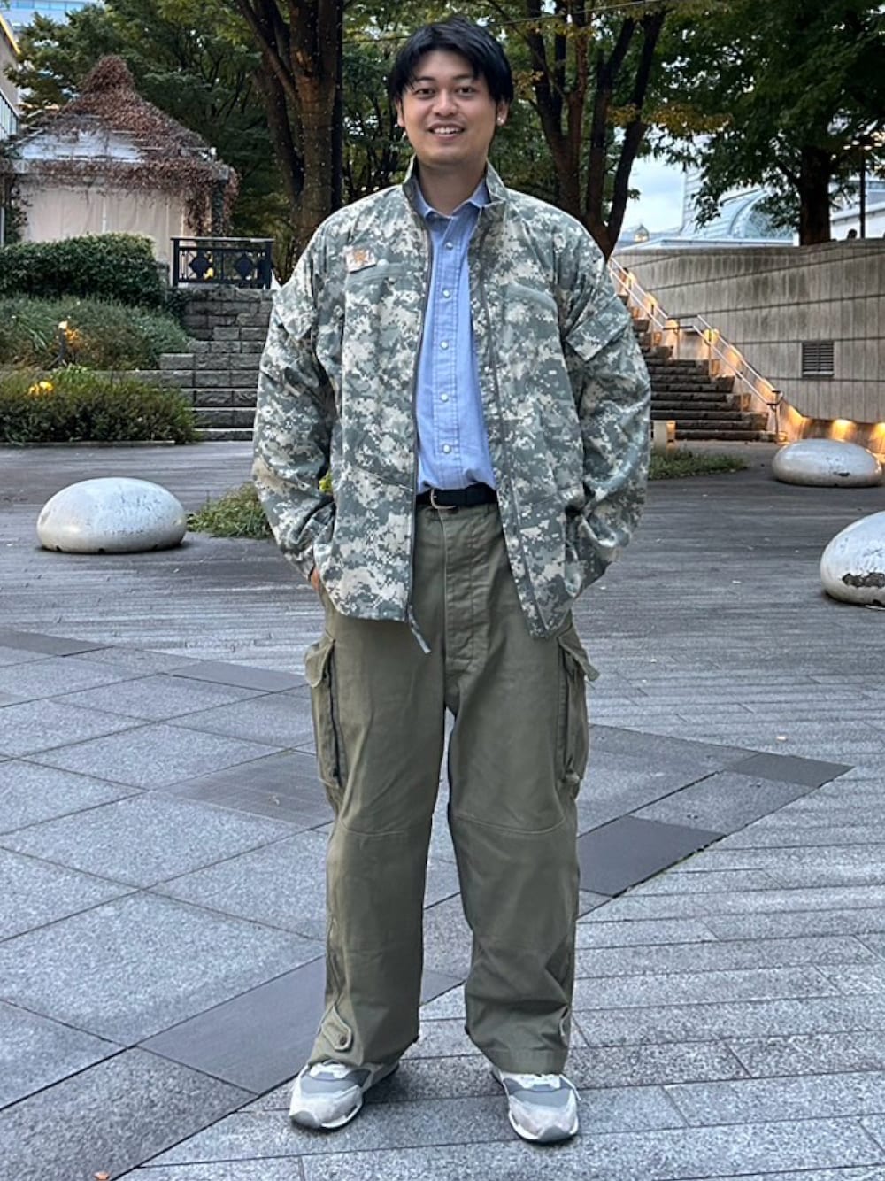 ブルー系のシャツ/ブラウス、グリーン系のミリタリージャケット、グリーン系のカーゴパンツを着用したメンズの秋コーディネートの1枚目の写真