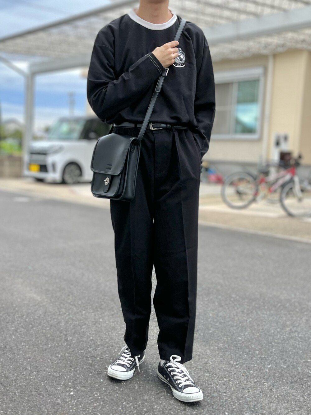 ブラック系のTシャツ/カットソー、ブラック系のショルダーバッグ、ブラック系のスニーカーを着用したメンズの秋コーディネートの1枚目の写真