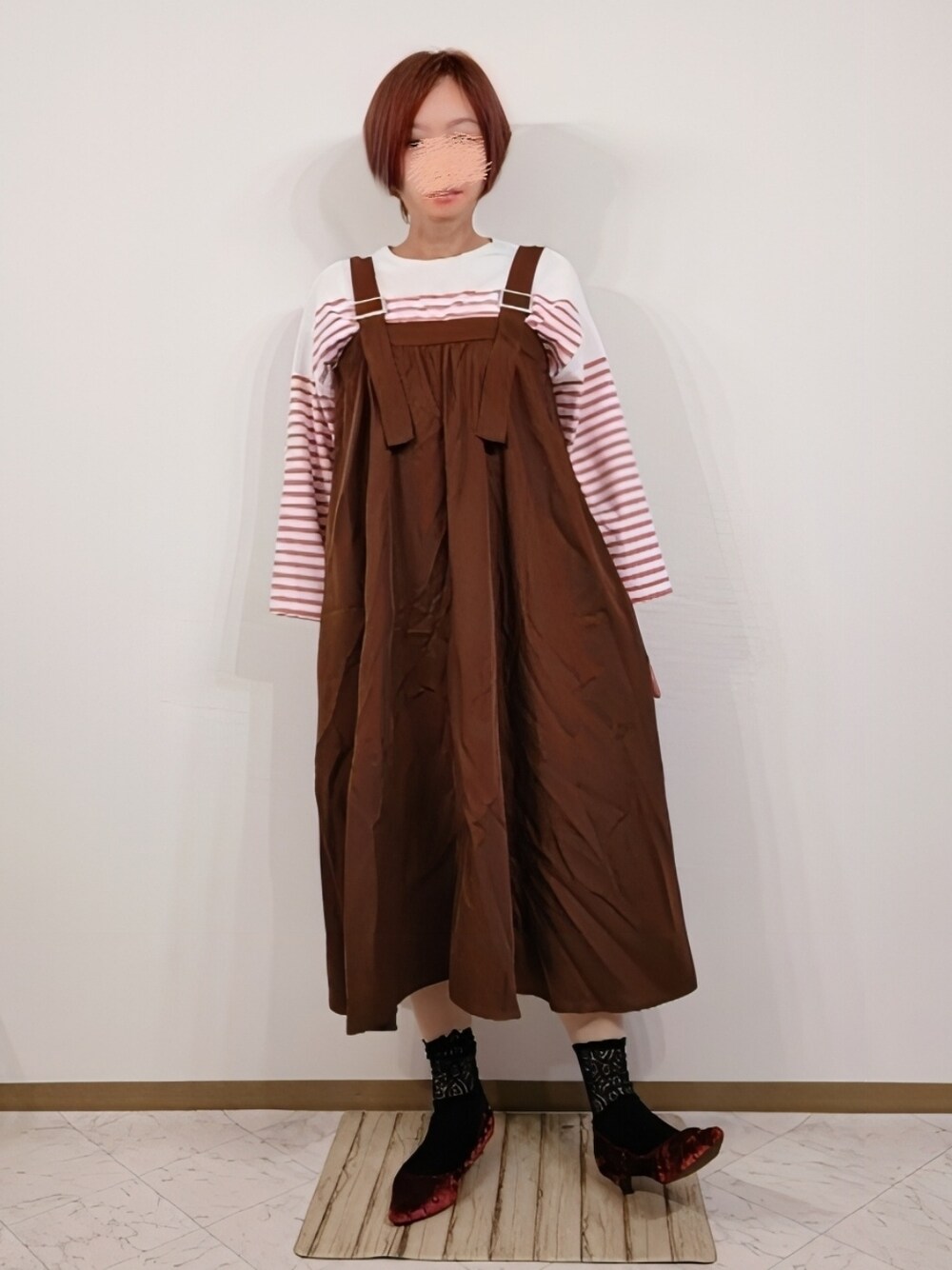 ピンク系のTシャツ/カットソー、ブラウン系のジャンパースカートを着用したレディースの冬コーディネートの1枚目の写真