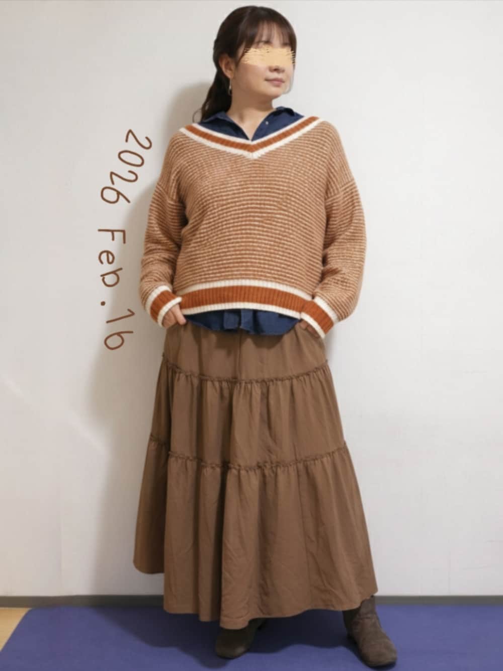 ブラウン系のスカート、レッド系のニット/セーター、ブルー系のシャツ/ブラウスを着用したレディースの冬コーディネートの1枚目の写真