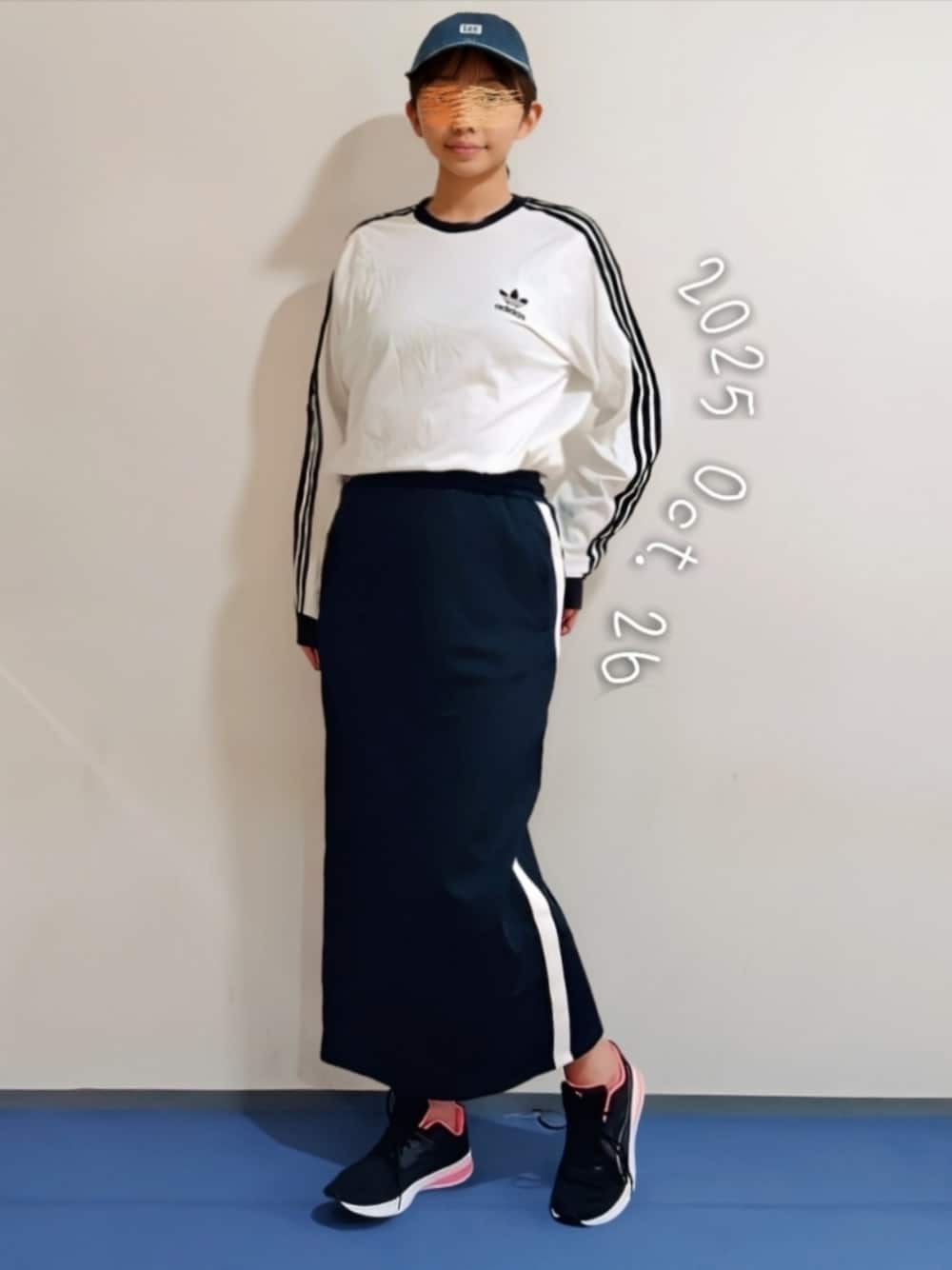 ブルー系のスカート、ホワイト系のTシャツ/カットソーを着用したレディースの秋コーディネートの1枚目の写真