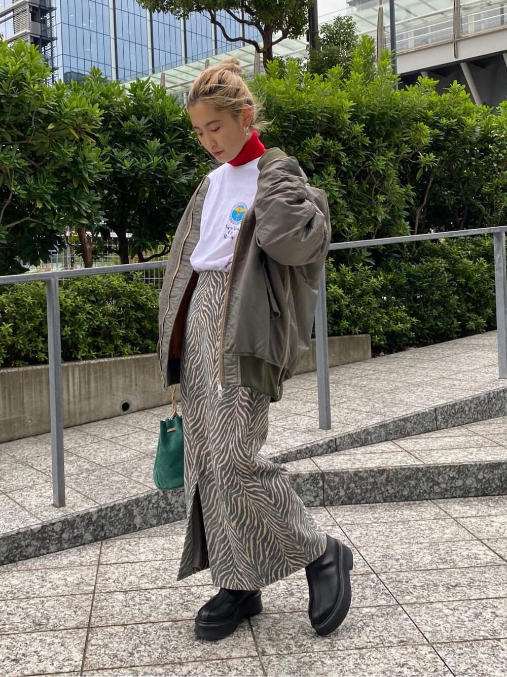 グリーン系のMA-1、レッド系のニット/セーター、ホワイト系のTシャツ/カットソーを着用したレディースの秋コーディネートの1枚目の写真