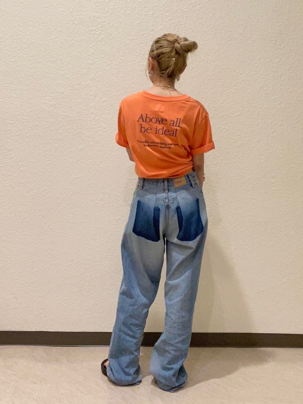 オレンジ系のTシャツ/カットソー、ブルー系のデニムパンツを着用したレディースの夏コーディネートの1枚目の写真