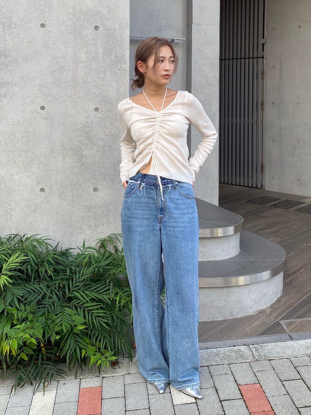 ホワイト系のニット/セーター、ブルー系のデニムパンツ、シルバー系のパンプスを着用したレディースの夏コーディネートの1枚目の写真
