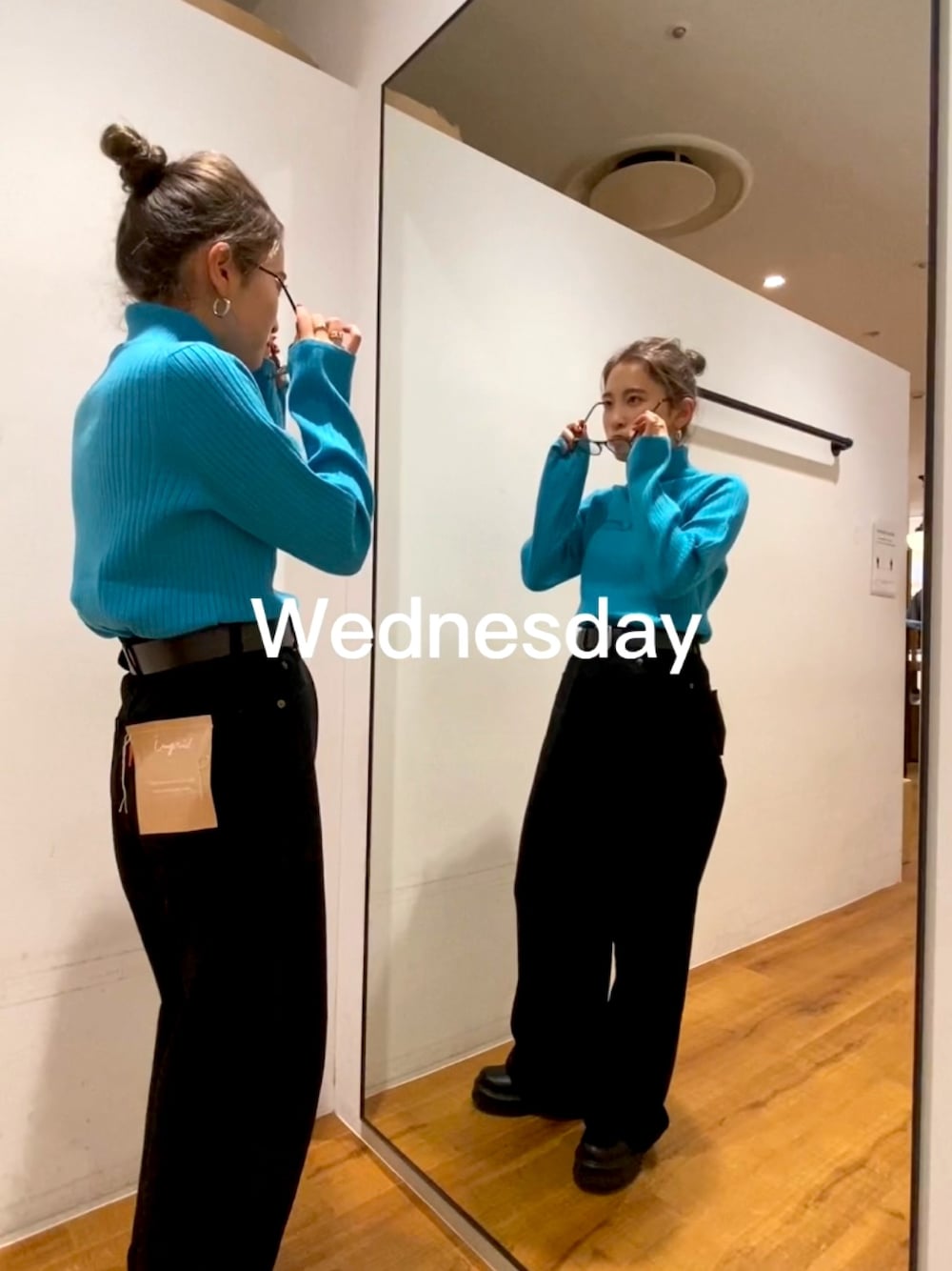 ブラック系のデニムパンツ、ブラック系のブーツ、ブルー系のニット/セーターを着用したレディースの秋コーディネートの1枚目の写真