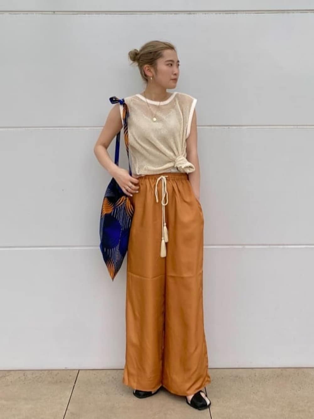 ブラック系のサンダル、オレンジ系のその他パンツ、ブルー系のショルダーバッグを着用したレディースの春コーディネートの1枚目の写真