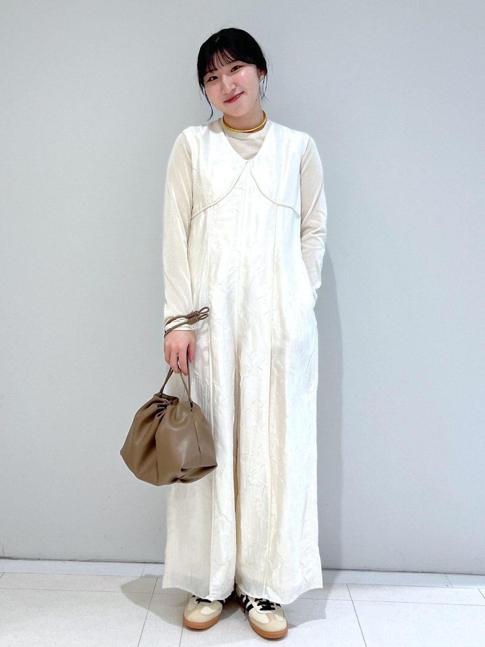 ホワイト系のTシャツ/カットソー、ブラウン系のショルダーバッグ、ホワイト系のつなぎ/オールインワンを着用したレディースの冬コーディネートの1枚目の写真