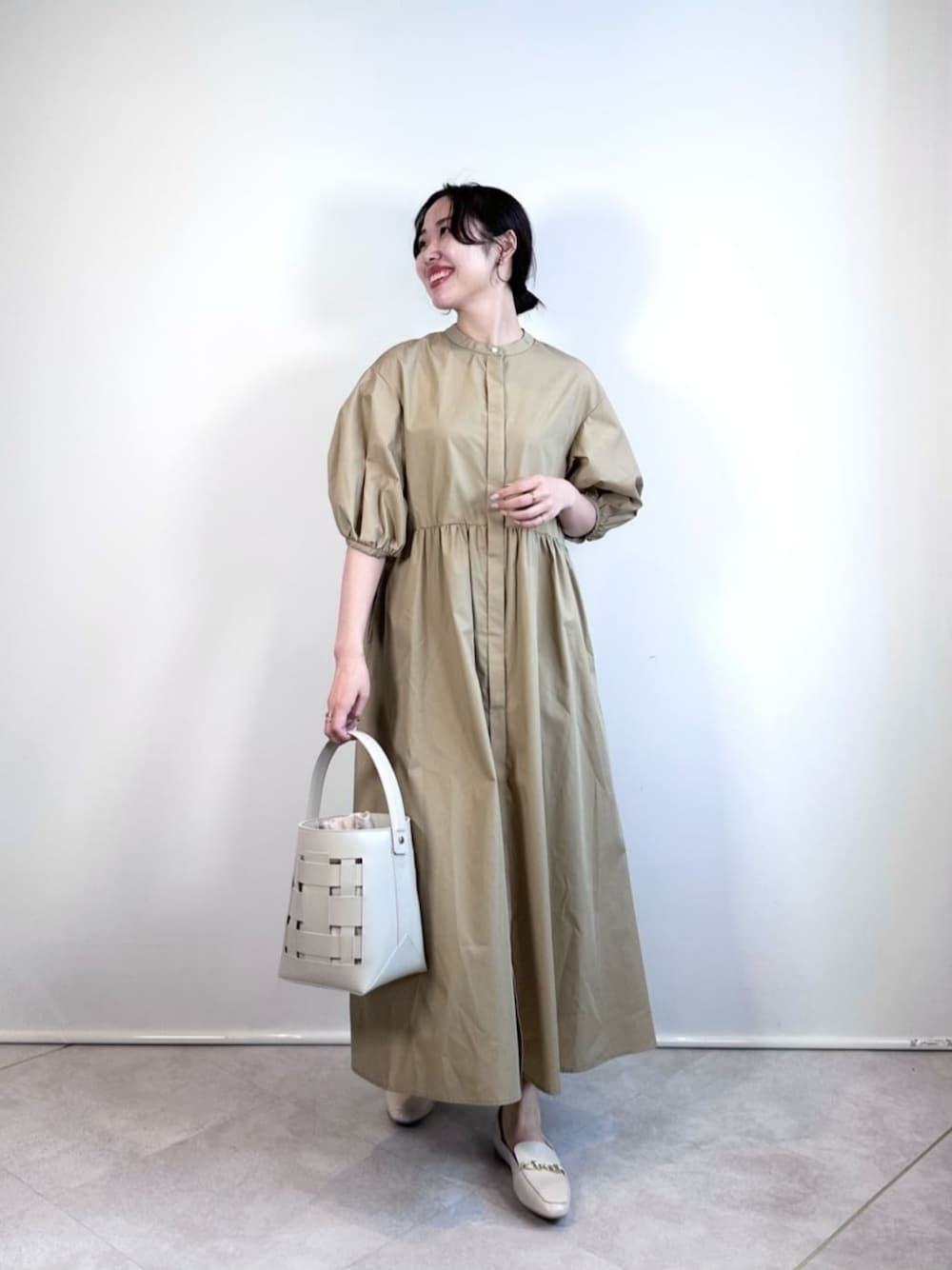 ホワイト系のショルダーバッグ、ベージュ系のワンピース、ベージュ系のその他シューズを着用したレディースの夏コーディネートの1枚目の写真