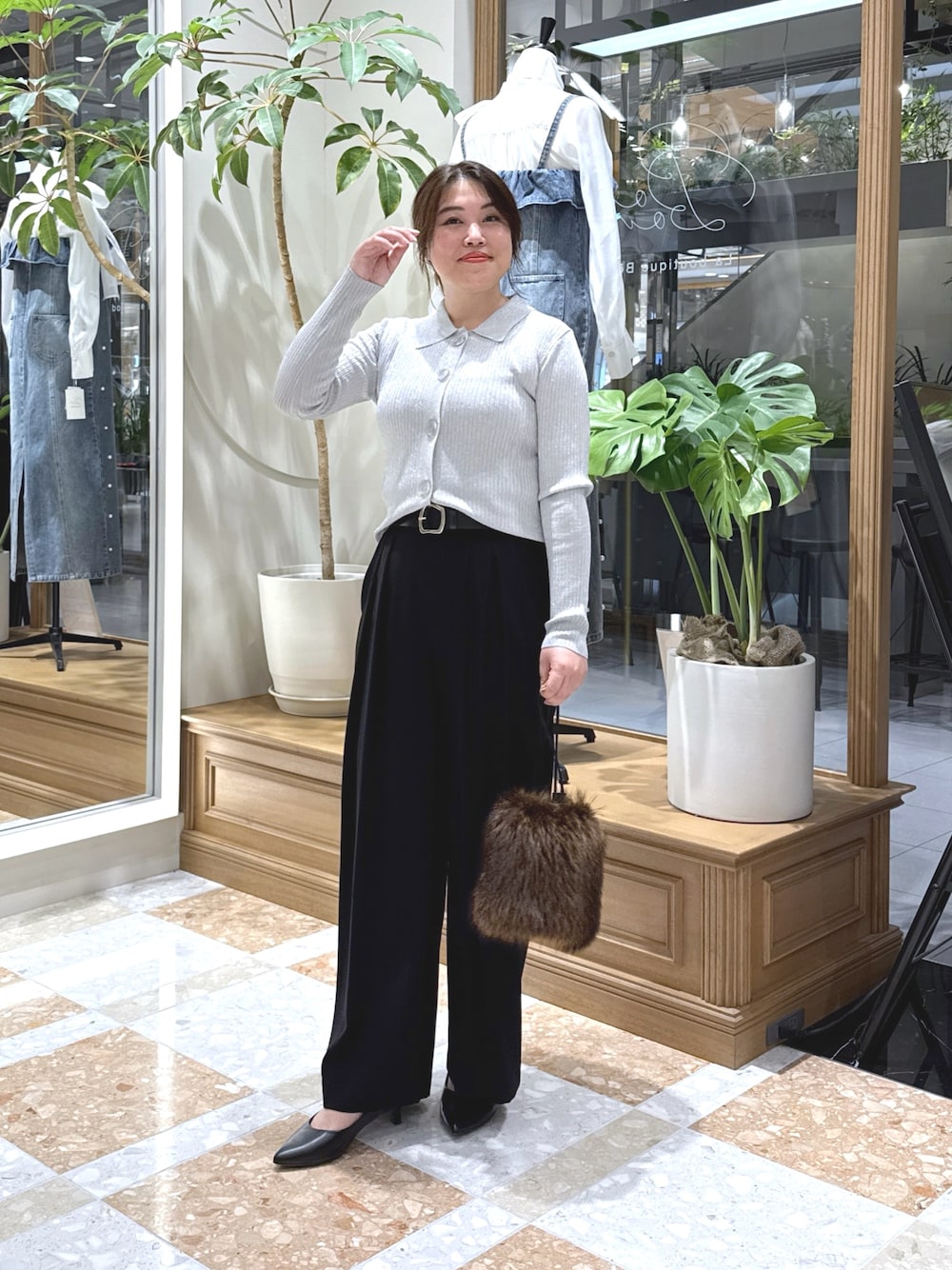 グレー系のニット/セーター、ブラック系のスラックス、ブラウン系のトートバッグを着用したレディースの秋コーディネートの1枚目の写真