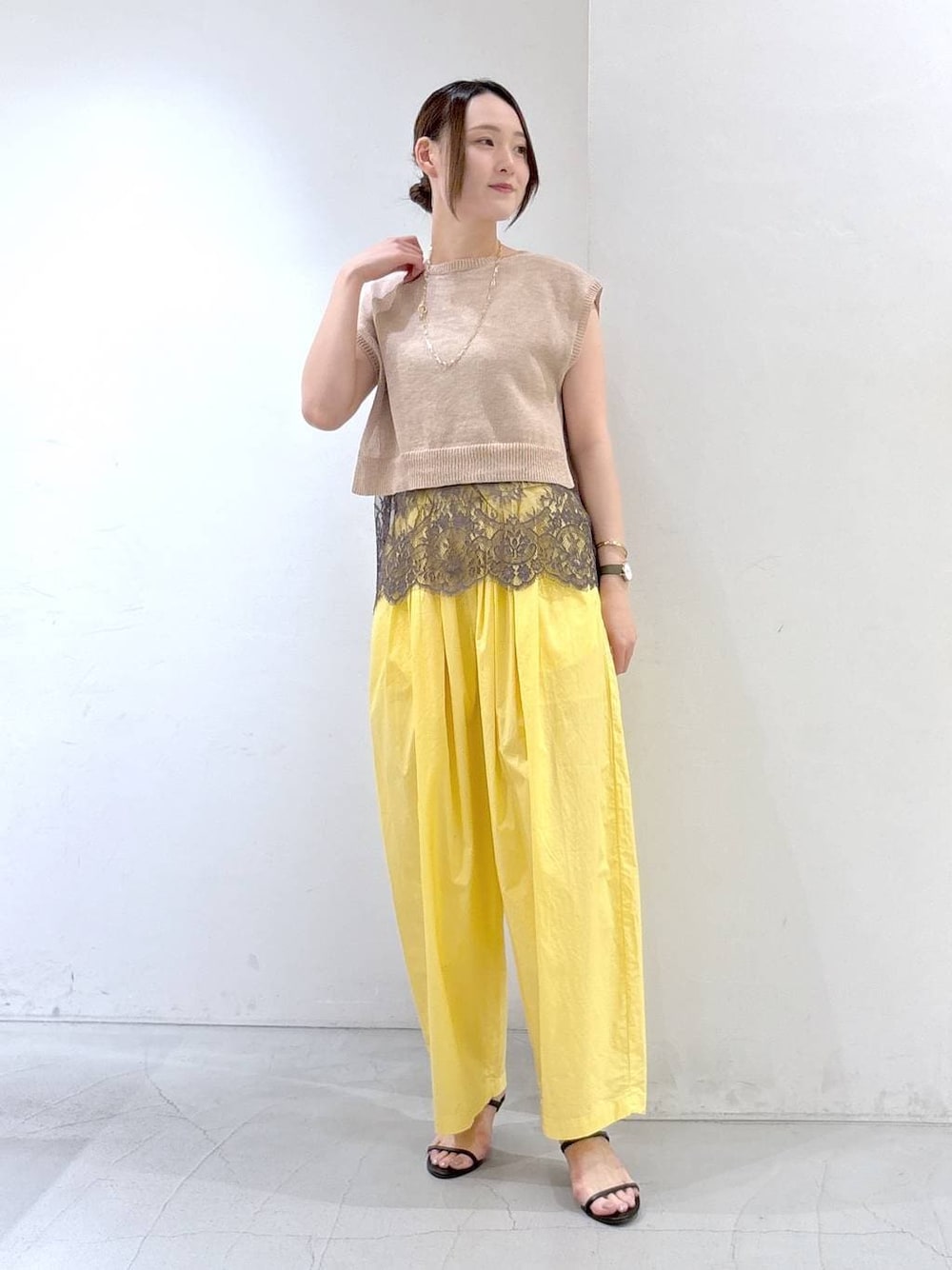 イエロー系のその他パンツ、ベージュ系のニット/セーターを着用したレディースの夏コーディネートの1枚目の写真